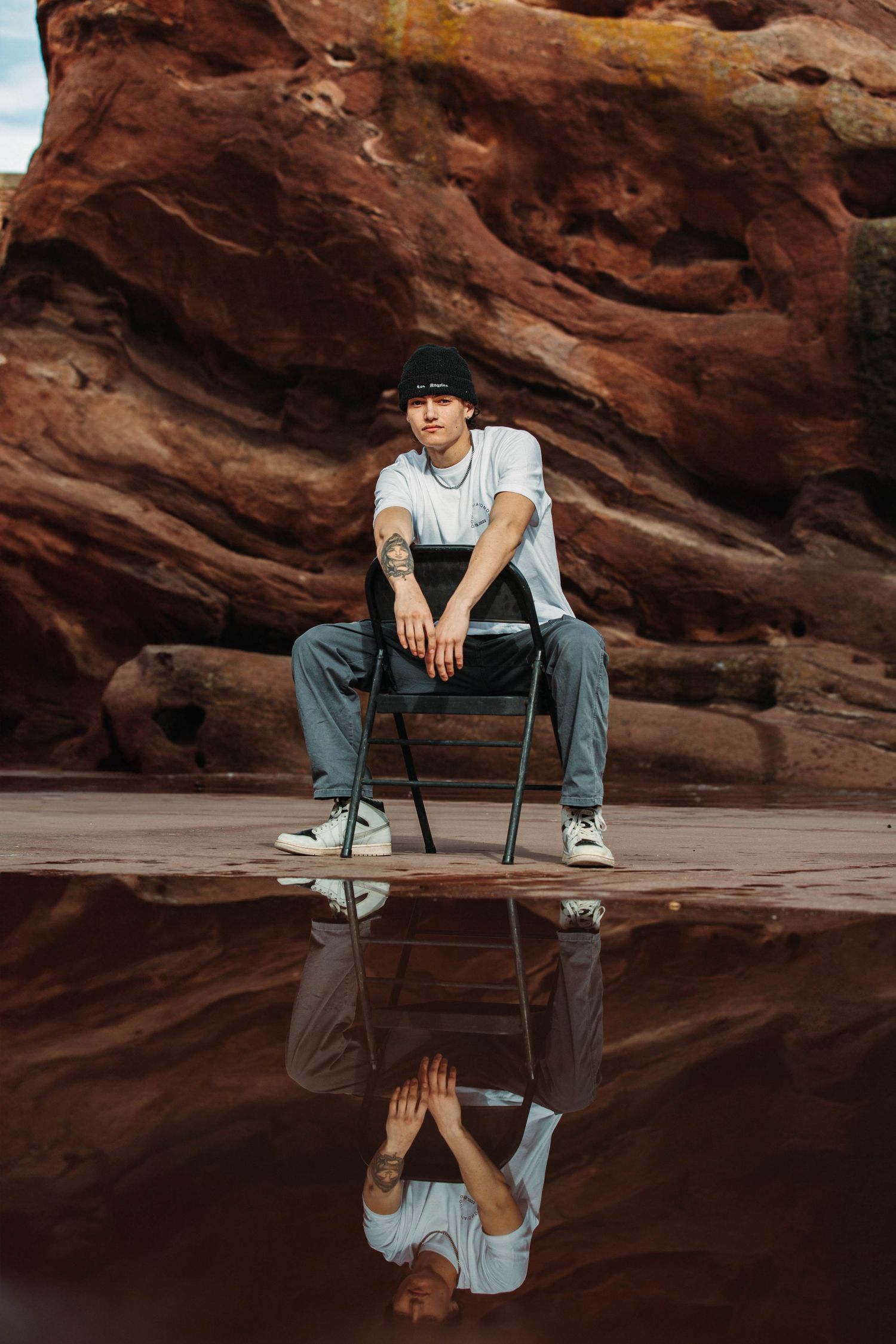 Branded photoshoot for local Denver Colorado clothing brand, Double Diamonds. Model posing in a chair, at of red rocks amphitheater