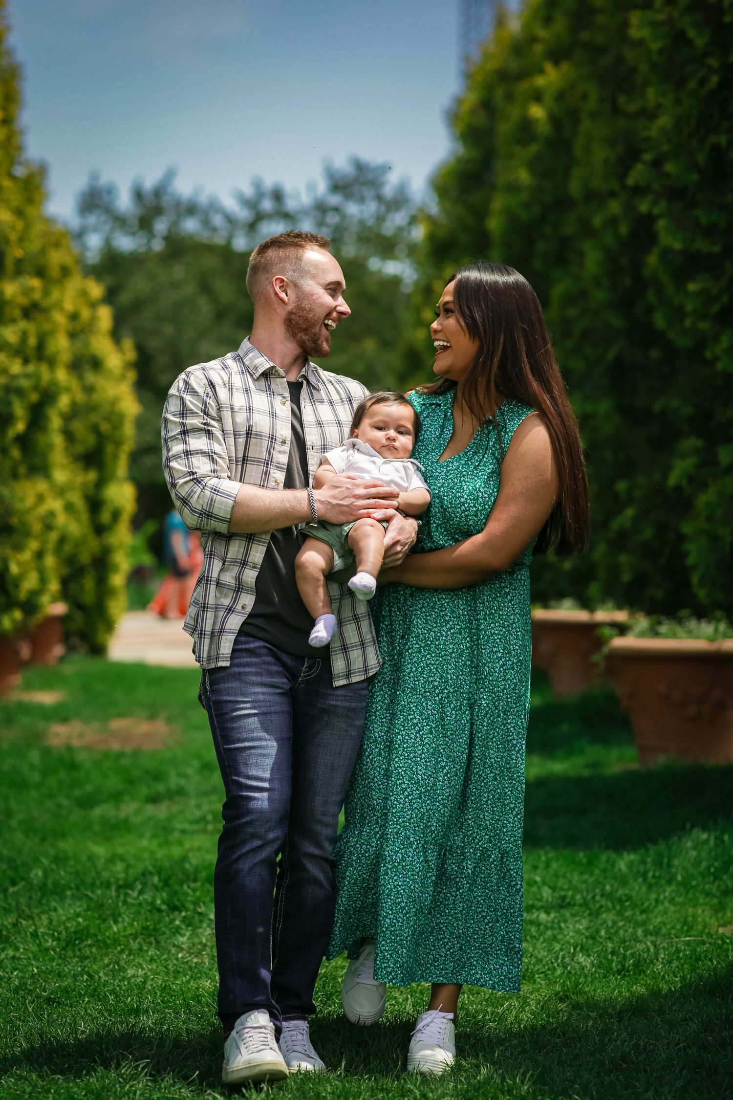 Couple walking and embracing their child together at the Denver Botanic Gardens