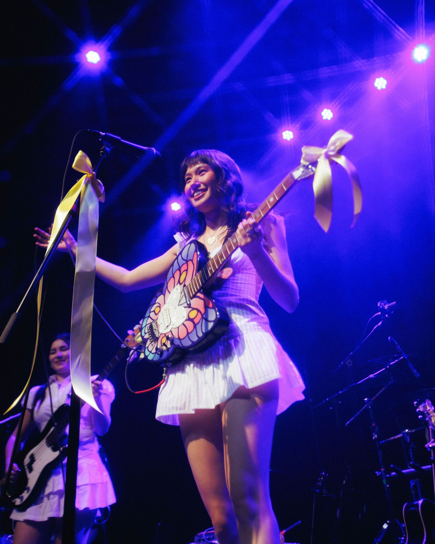 Medium shot of Juliet Ivy, with her iconic butterfly guitar while opening for mxmtoon on the Liminal Space Tour