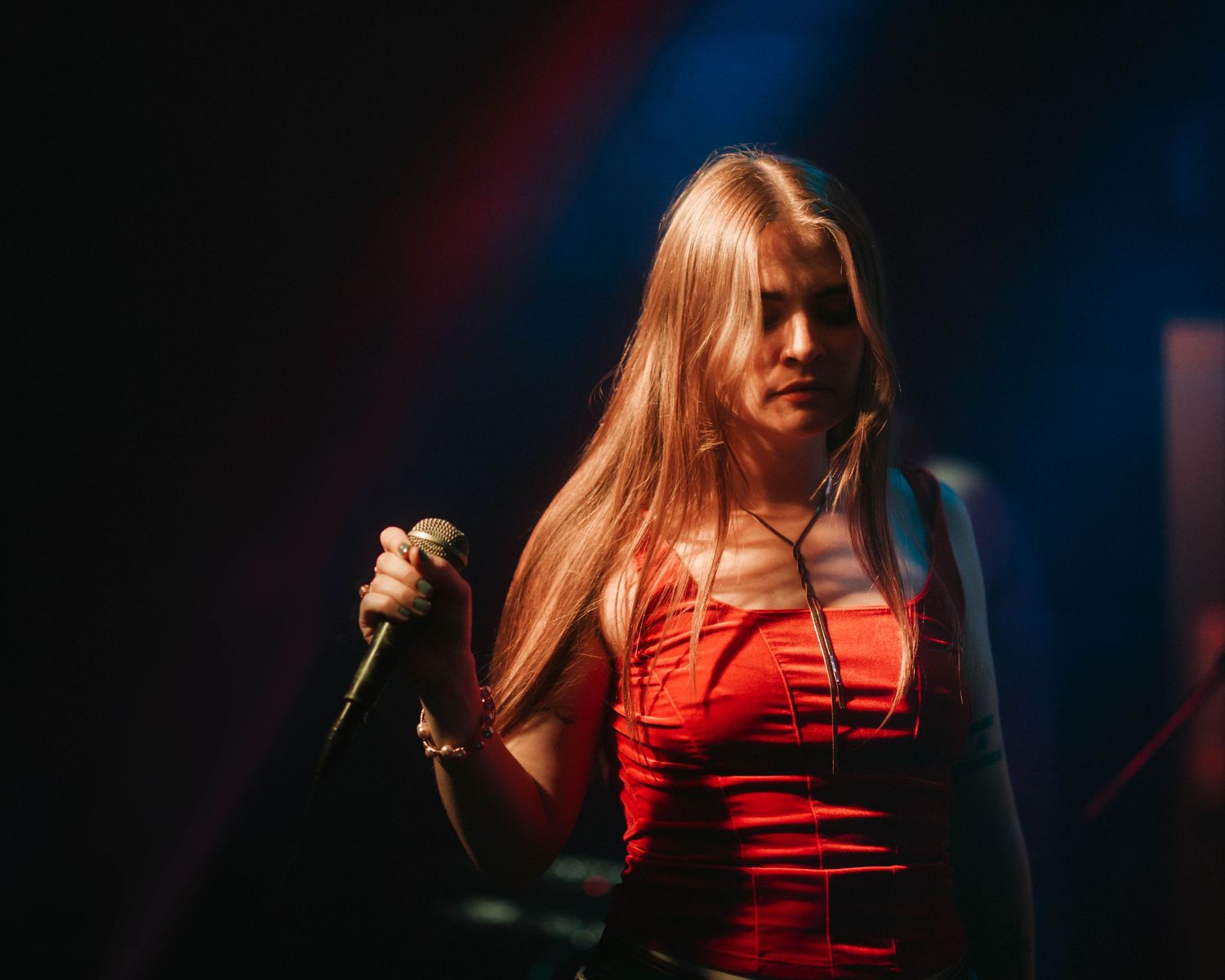 Close up of colorado's Cameron Cade, on stage with dramatic lighting, performing the opening set for Kenzie Cait on the Over Nostalgic Tour