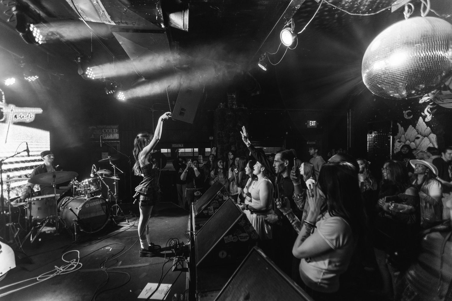 Black and white, wide angle shot of Kenzie Cait, interacting with fans while on The Over Nostalgic Tour at Lost Lake Denver