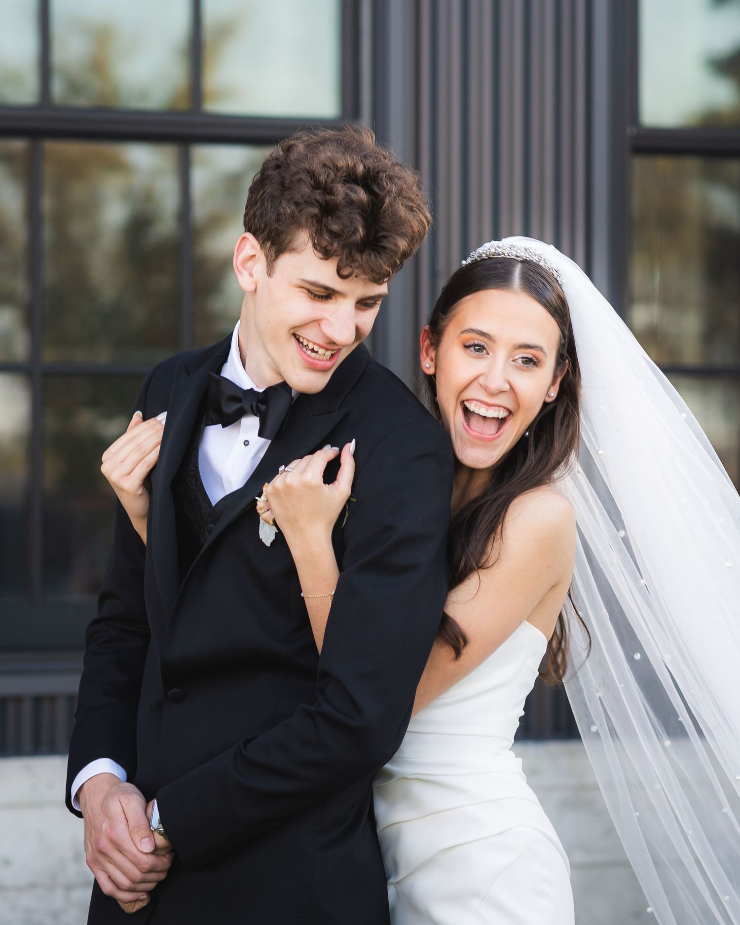 Storrie/Longoria Wedding, bride hugging groom from behind at The Windsor Mill Event Center