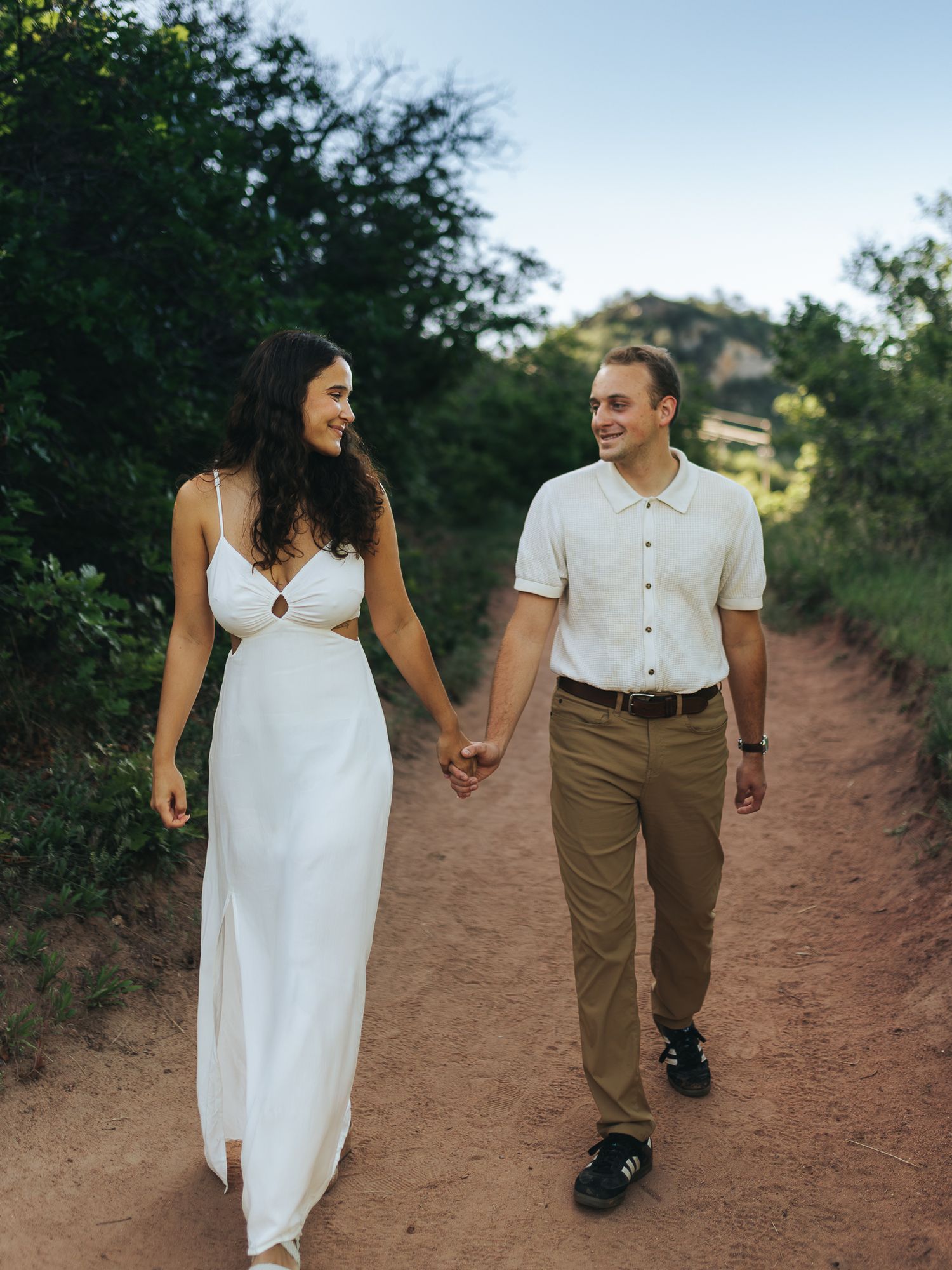 Couple holding hands and walking a trail at South Valley Park during sun rise