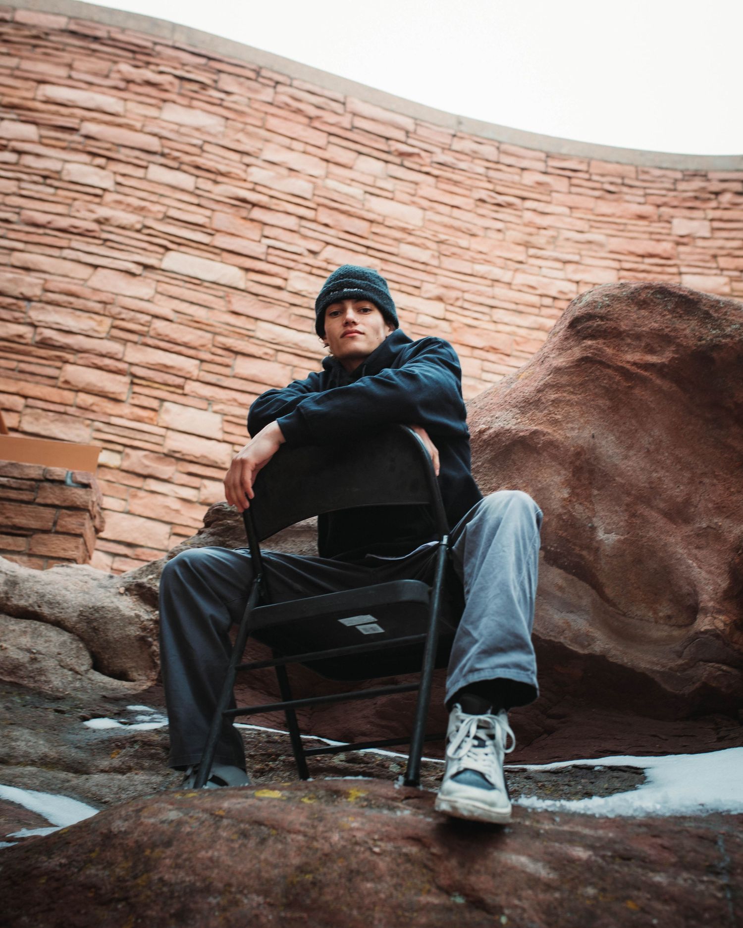 Branded photoshoot for local Denver Colorado clothing brand, Double Diamonds. Model posing in a chair, on top of red rocks amphitheater