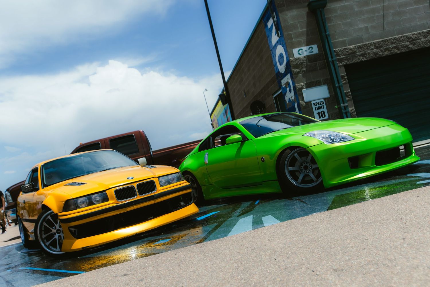 Yellow e36 and Green 350 Z parked side by side at Down To Earth Ascend, at PPIR in Colorado Springs, Co