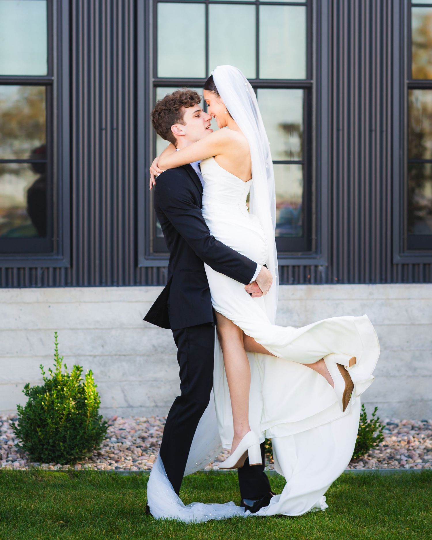 Storrie/Longoria Wedding, groom lifting his newly wedded wife at The Windsor Mill Event Center