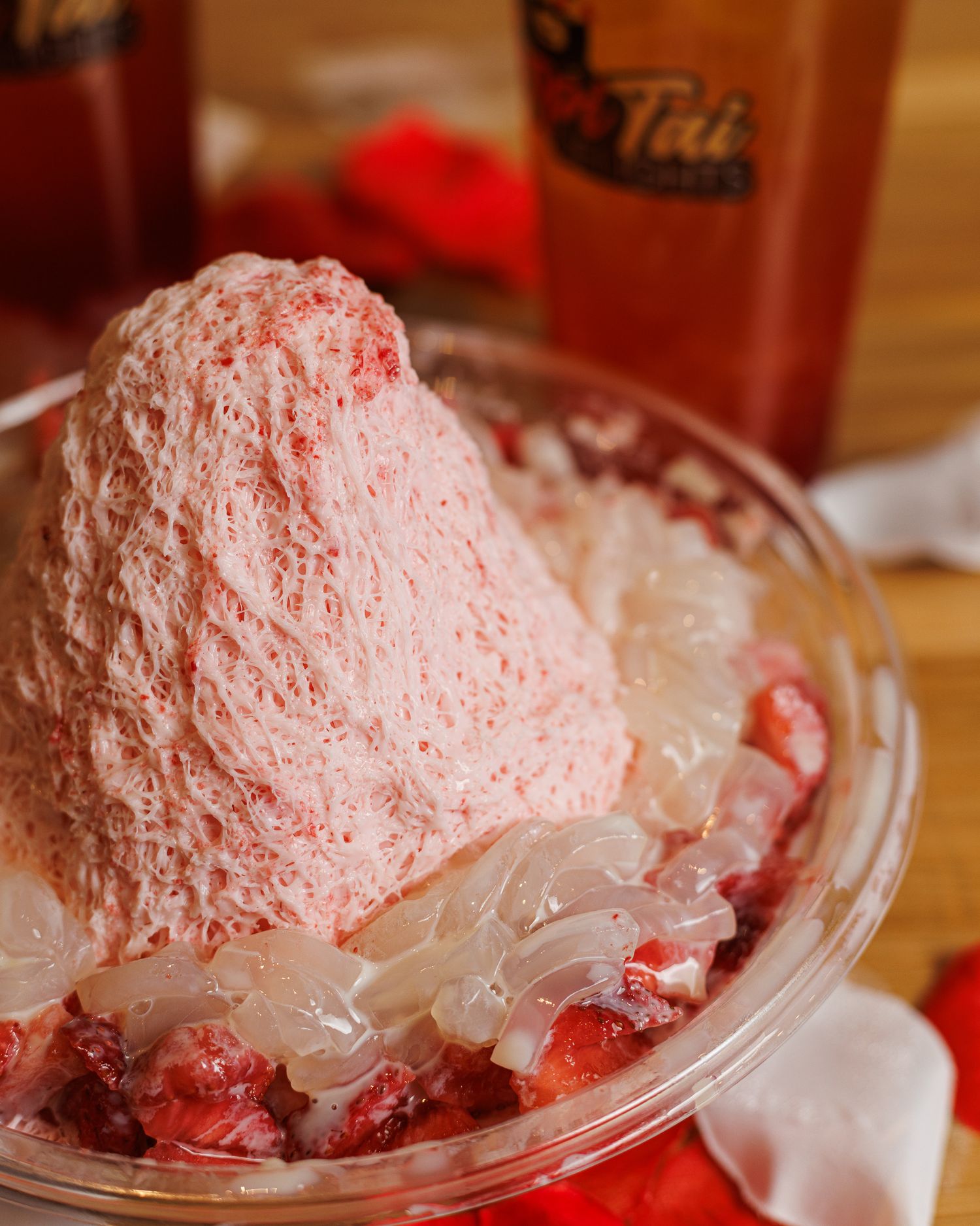 Close up shot of Taiwanese Strawberry Shaved Ice with fresh strawberries, condensed milk, and mochi on the side from TropiTai Delights