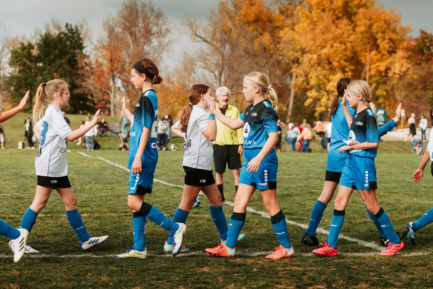 Children, high fiving and shaking hands after a NORCO Rush Soccer game