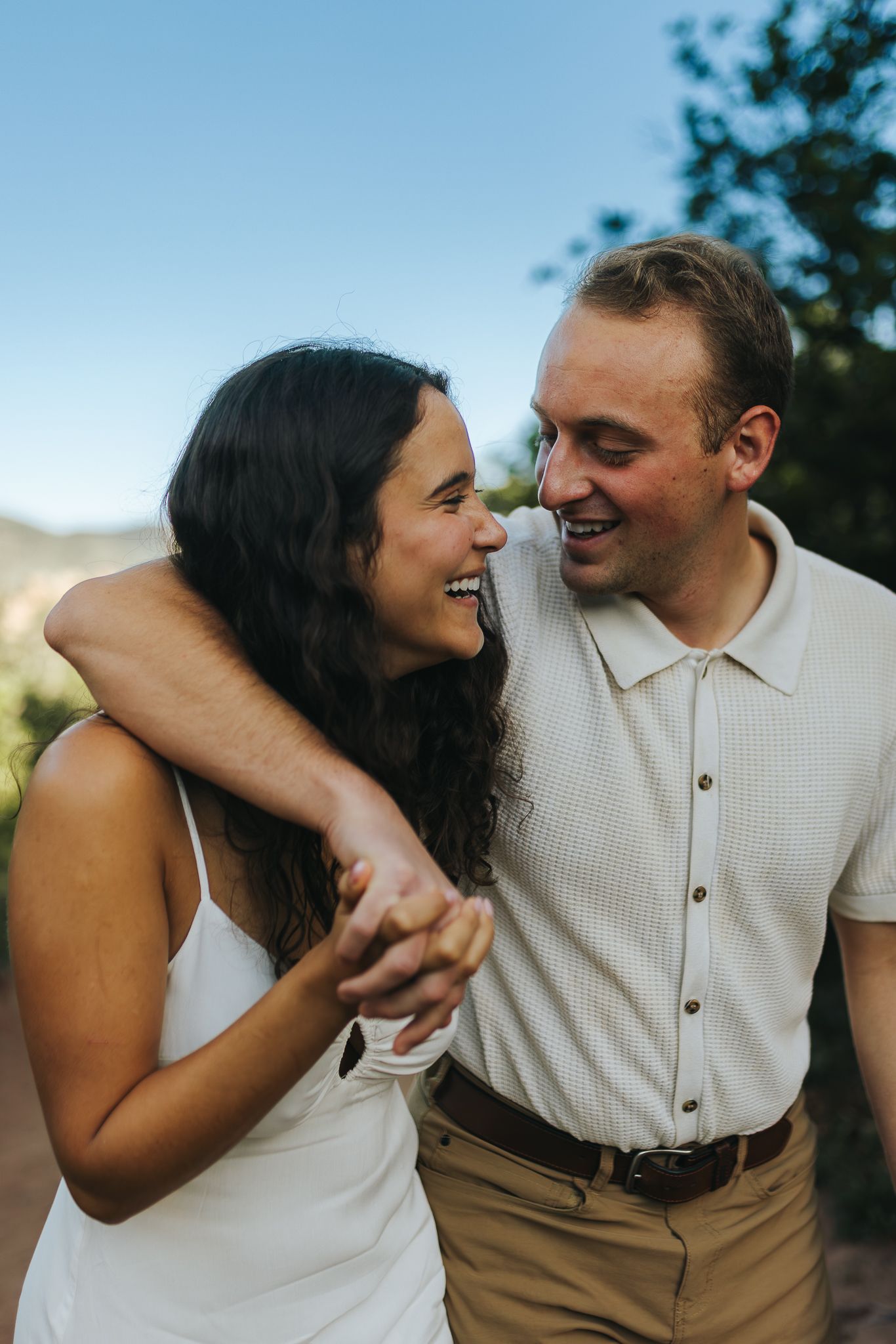 Couple embracing each other, while looking and smiling at eachother during sun rise.
