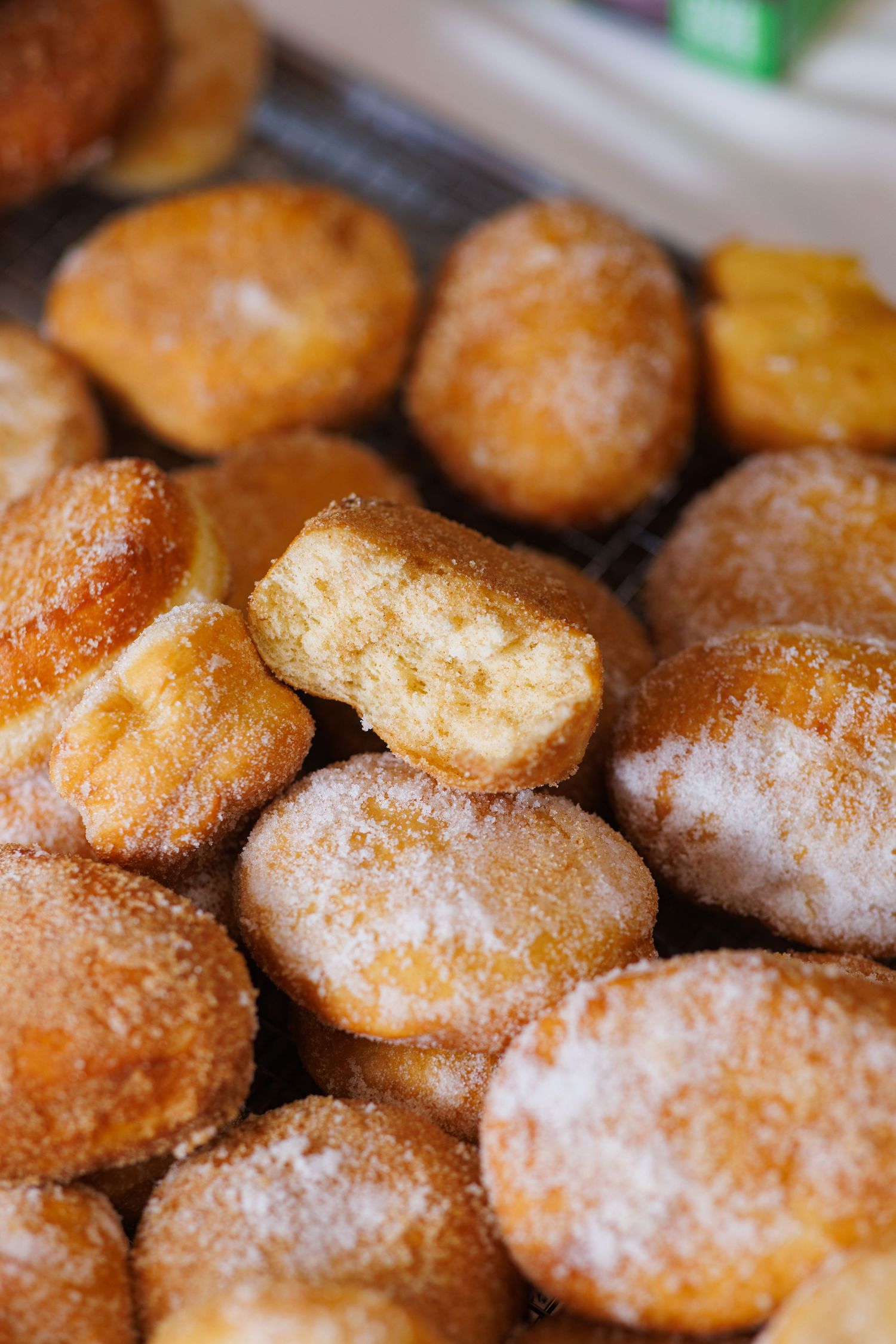 Close up shot of the inside of a freshly fried, sugar coated, malasada from TropiTai Delights Dessert Shop