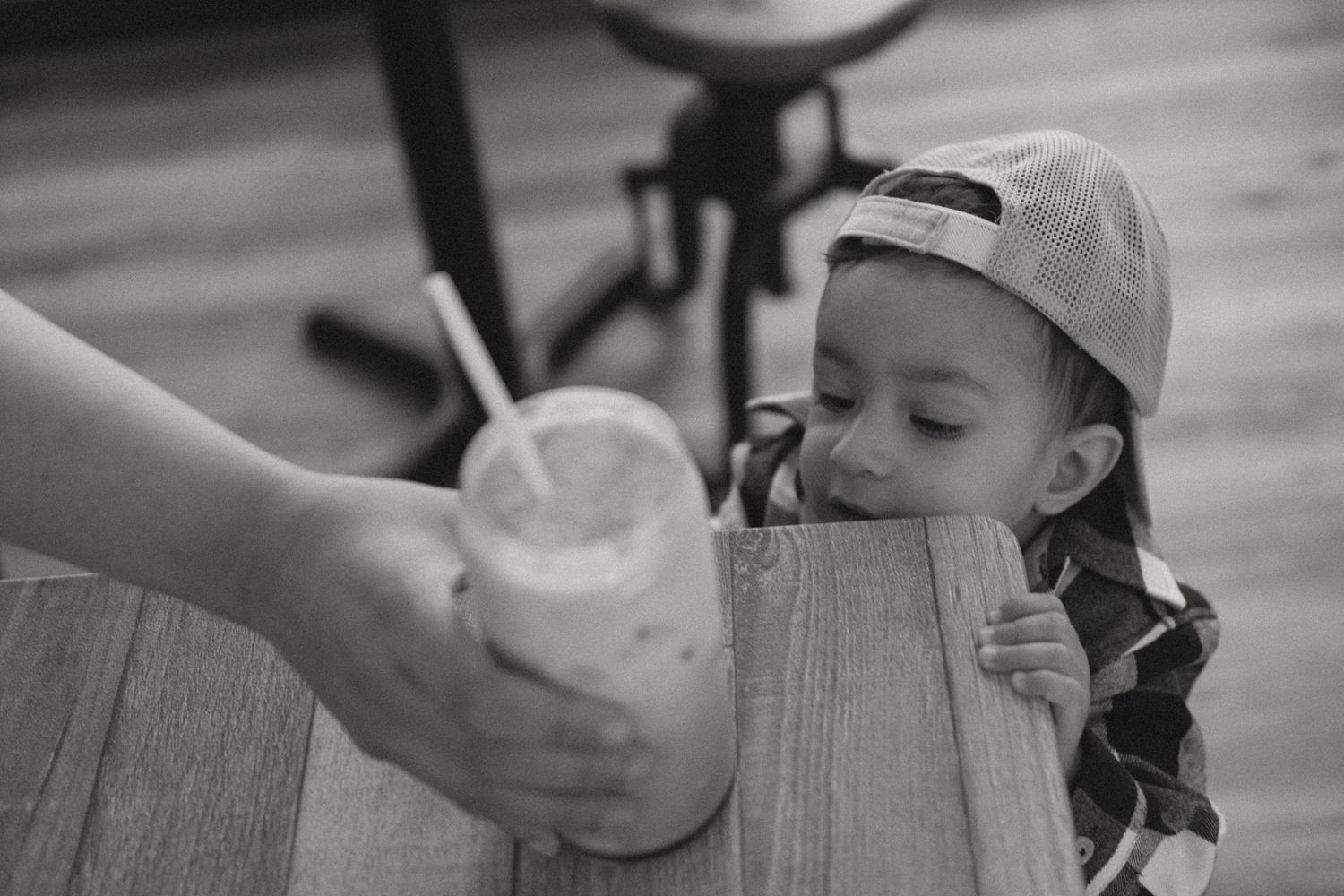 A family lifestyle photoshoot. Toddler peeking over the table. Candid photo.