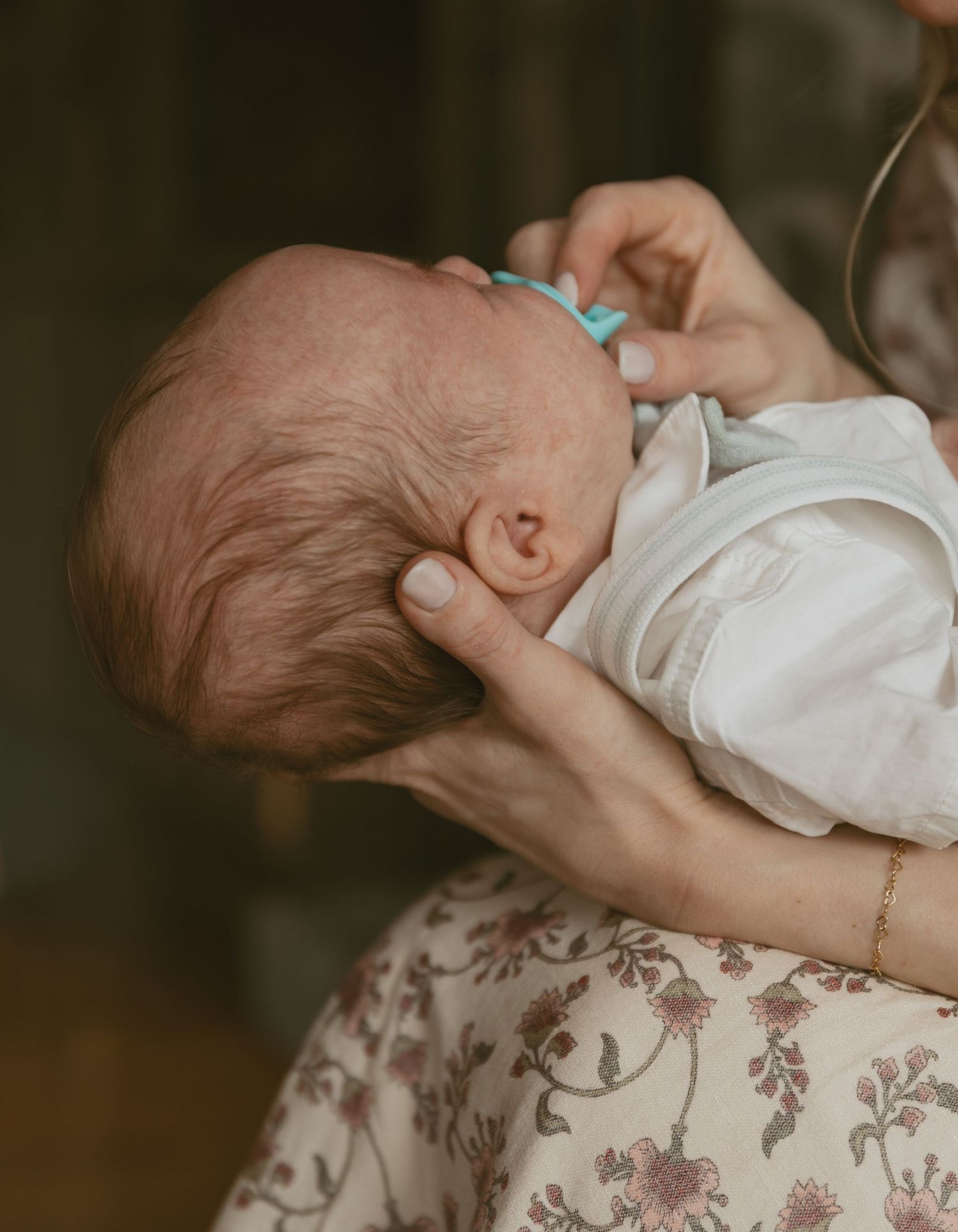 Newborn photos in family cabin in Sullivan County New York, Catskills. Emotive image of mom holding baby, and detail shot of newborns hair.