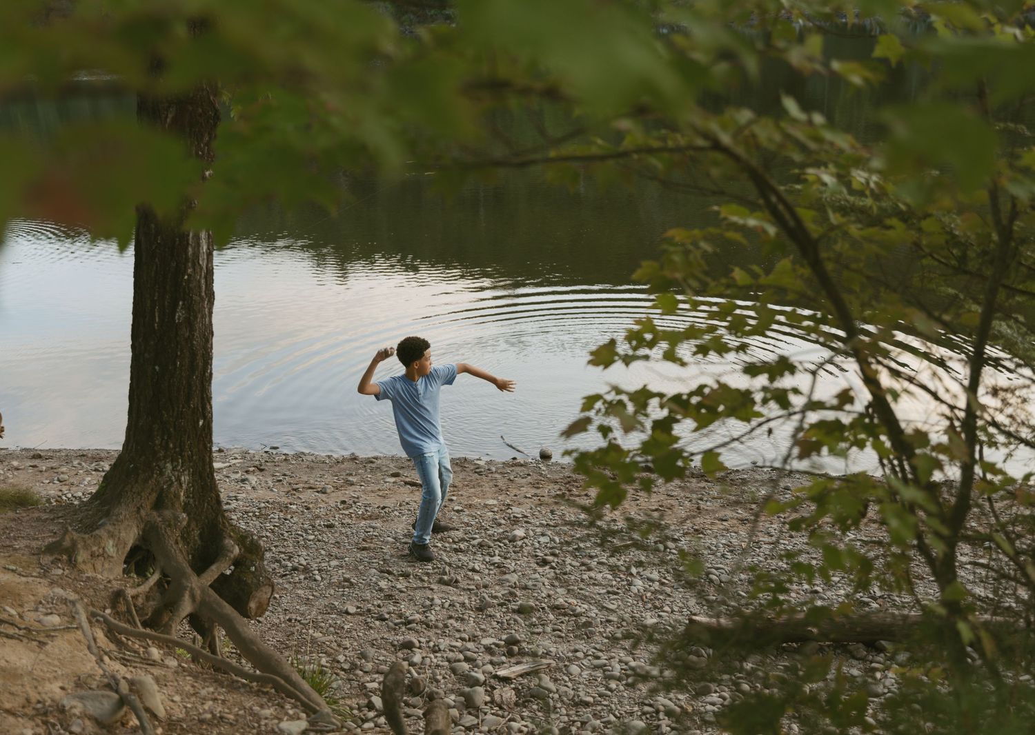 Family photos in Sullivan County New York, Catskills. Family photo of son skipping rocks in the water