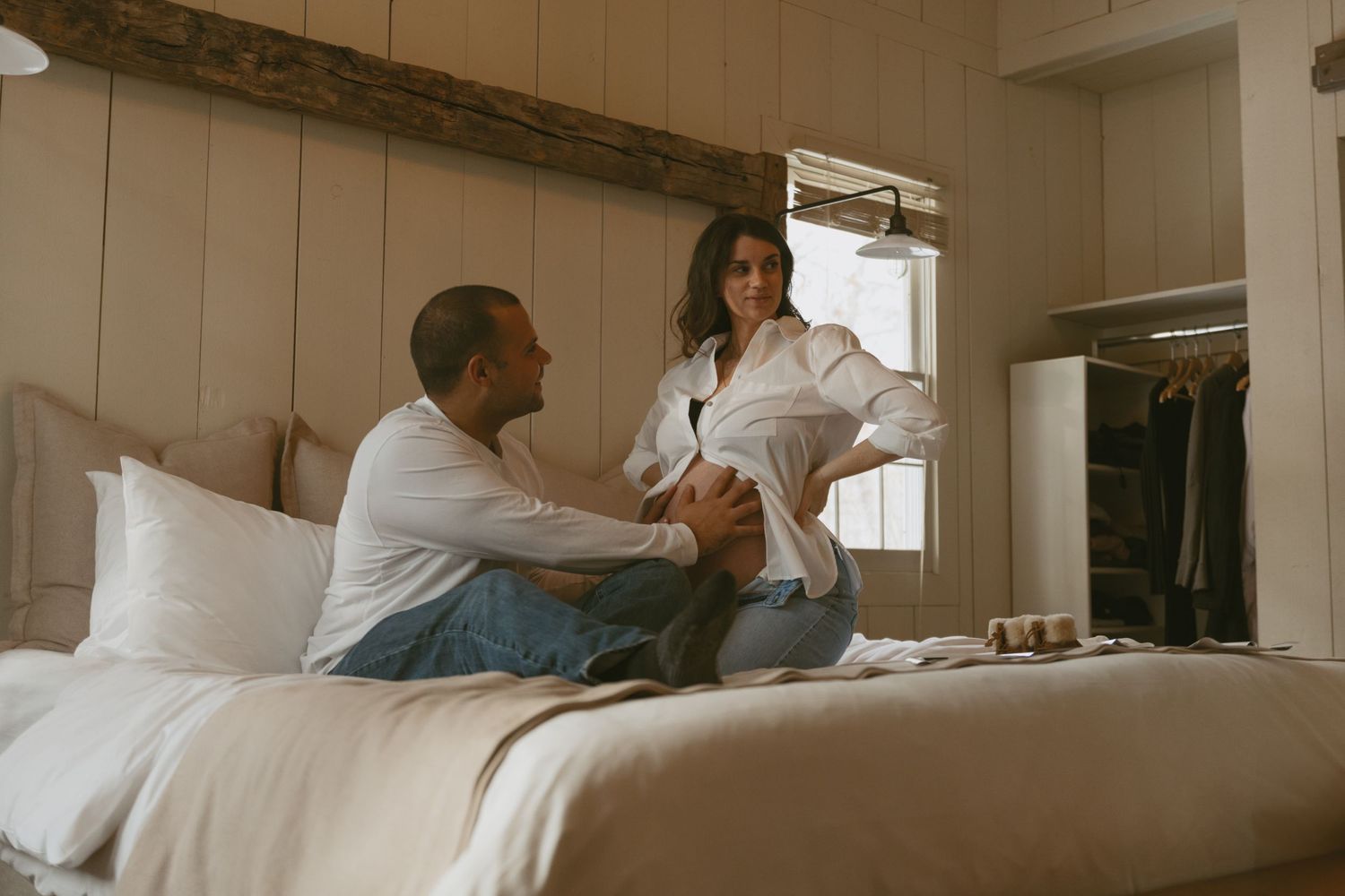 Cozy Editorial indoor maternity photos in the sleepy pine cottage at Cedar Lake Estates in Port Jervis, New York. Dad holding mom's bump