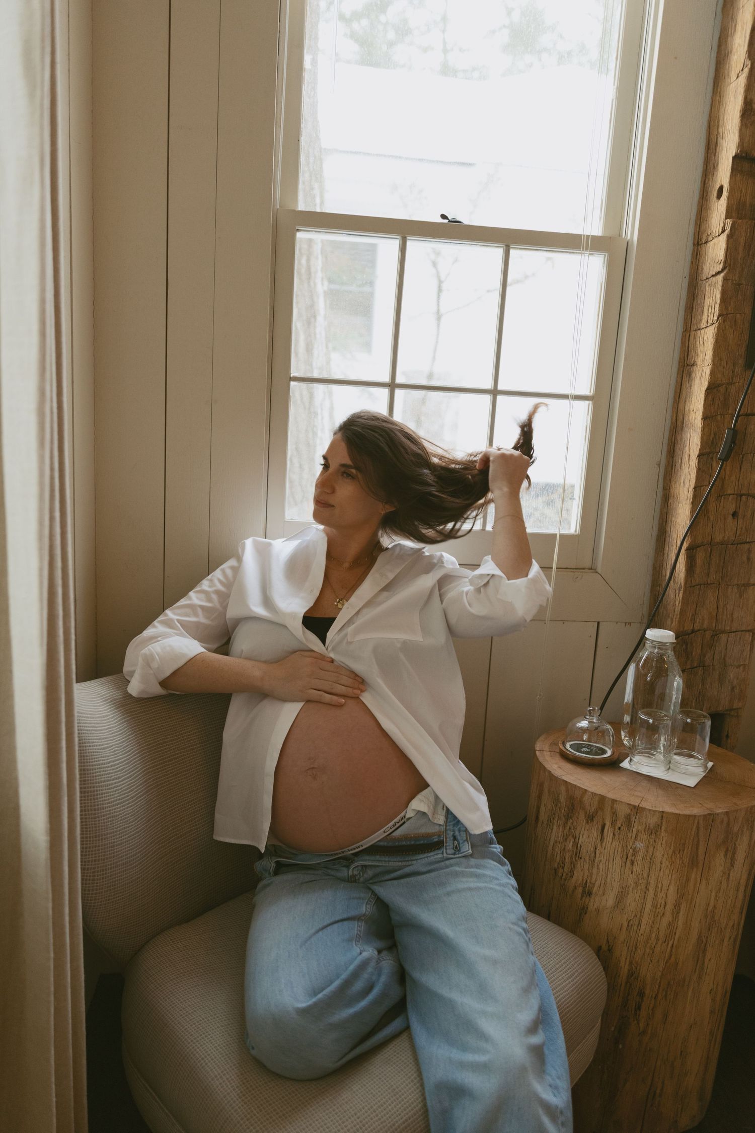 Cozy Editorial indoor maternity photos in the sleepy pine cottage at Cedar Lake Estates in Port Jervis, New York. Mom playing with hair