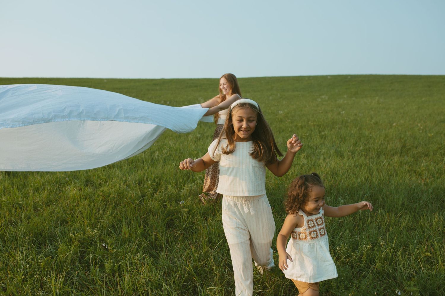 Documentary and candid, play-based summer family photo running through a field at sunset in Sussex county New Jersey