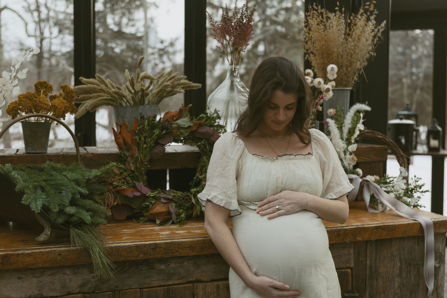 Cozy Editorial indoor maternity photos in the Glasshouse at Cedar Lake Estates in Port Jervis, New York. Mom holding baby bump