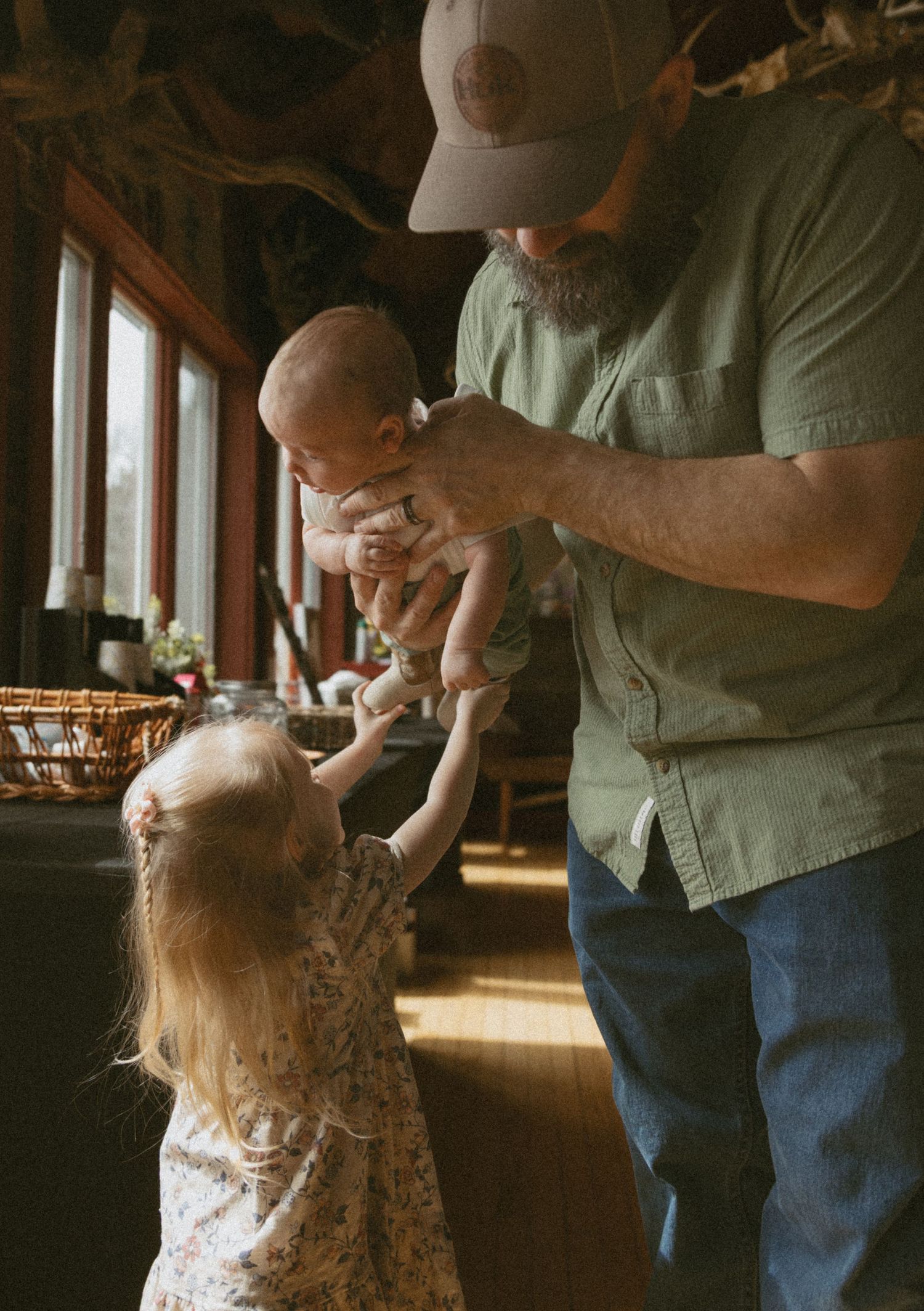 Newborn  photos at family cabin in Sullivan County New York, Catskills. Toddler reaching for newborn baby in dad's arms