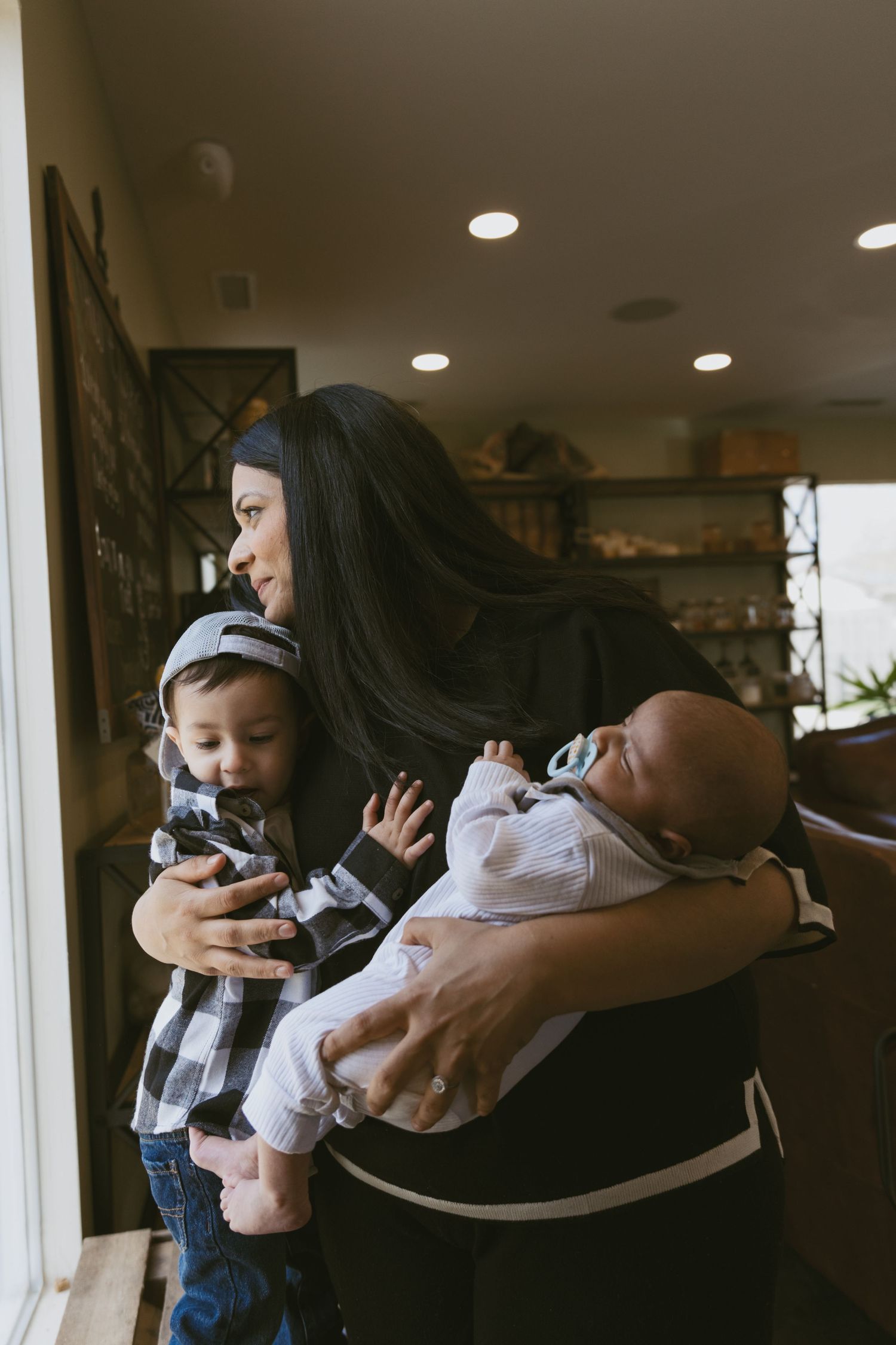 A motherhood session with her family in a coffee shop looking out the window.