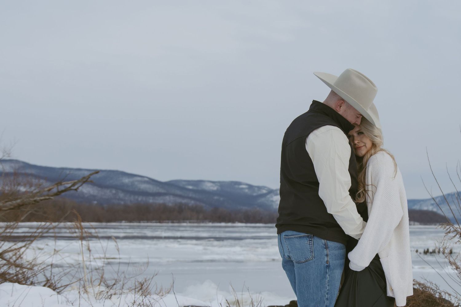 Cinematic winter western couple photo with the snowy mountains behind them, in Hudson valley New York