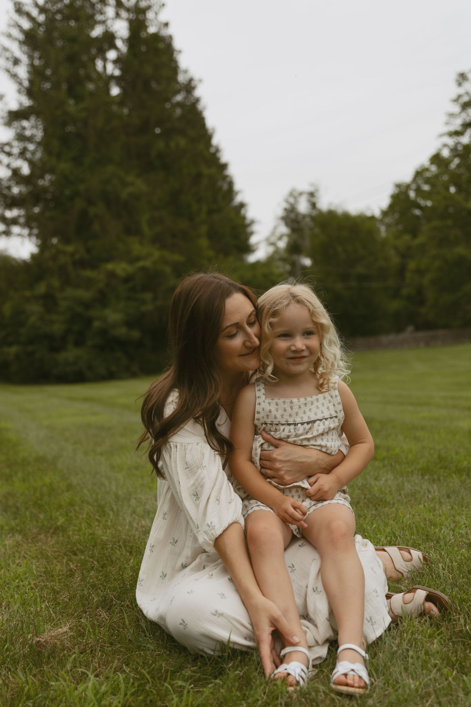 A motherhood photo of a mom hugging her daughter in a field at sunset in Milford, Pennsylvania.
