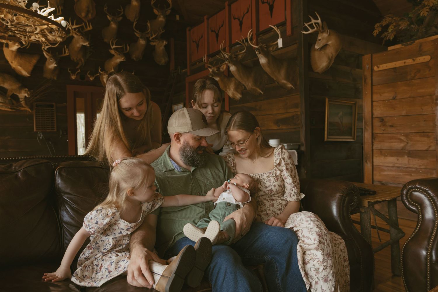 Newborn photos in family cabin in Sullivan County New York Catskills, Family on couch looking at baby