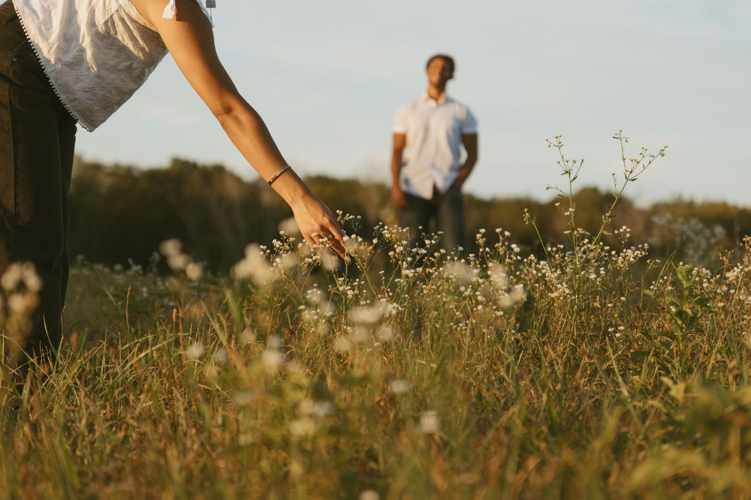 Cinematic Couple photo in a field picking flowers during golden hour in Sussex County New Jersey