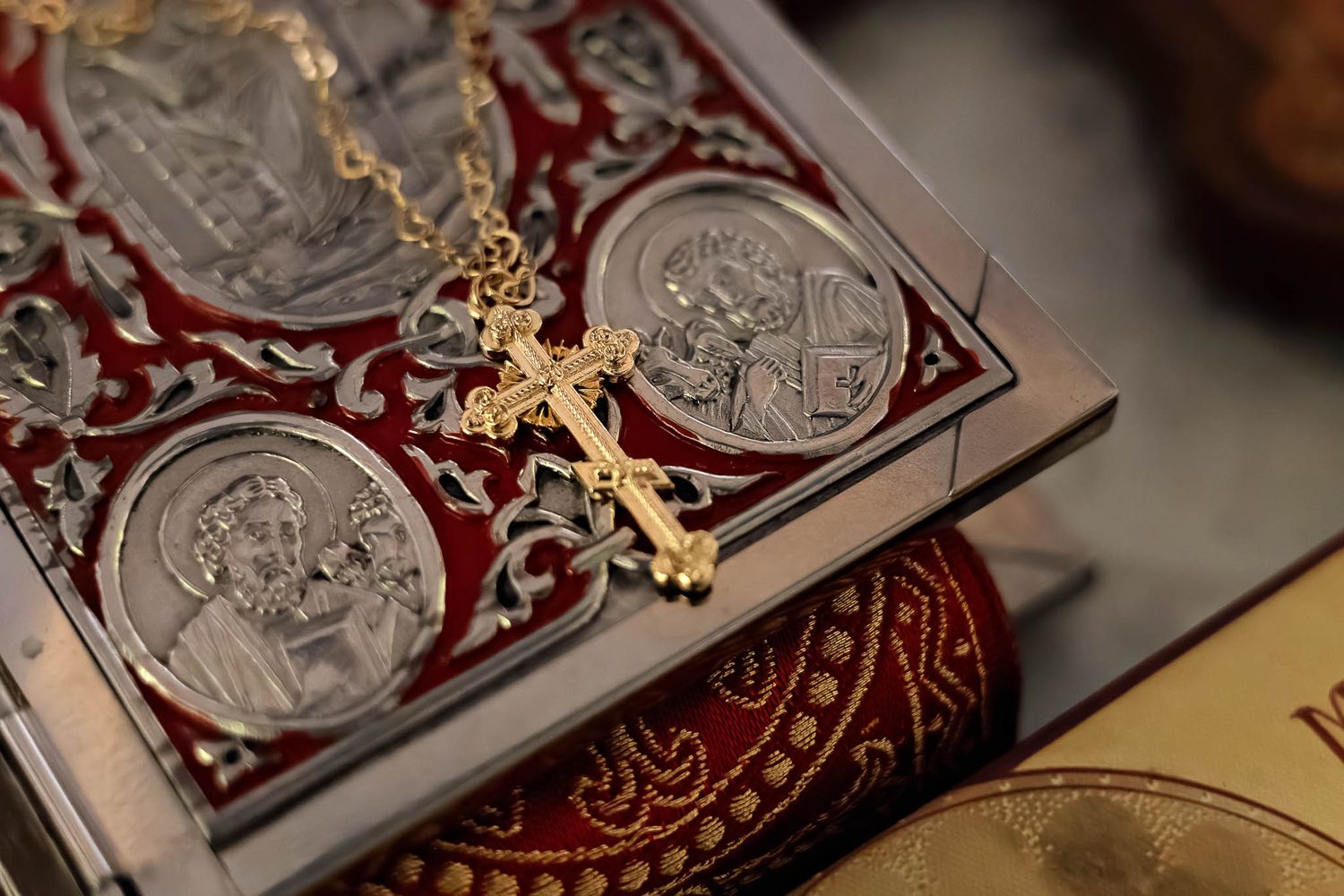 Detailed view of a beautiful, ornate Gospel book and baptismal cross used in Orthodox liturgical life.