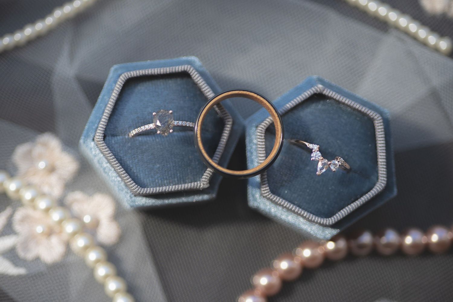 Orthodox wedding rings in blue velvet boxes with a strand of pearls.