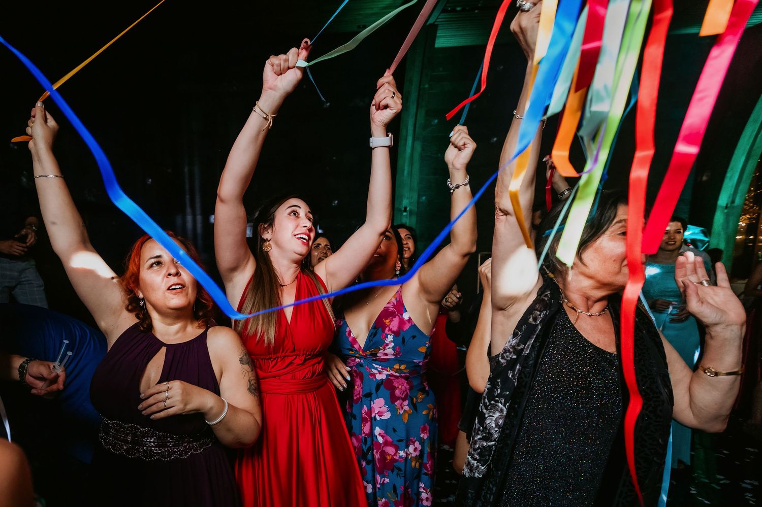 Excited women dance and wave colorful ribbons at a festive celebration party.