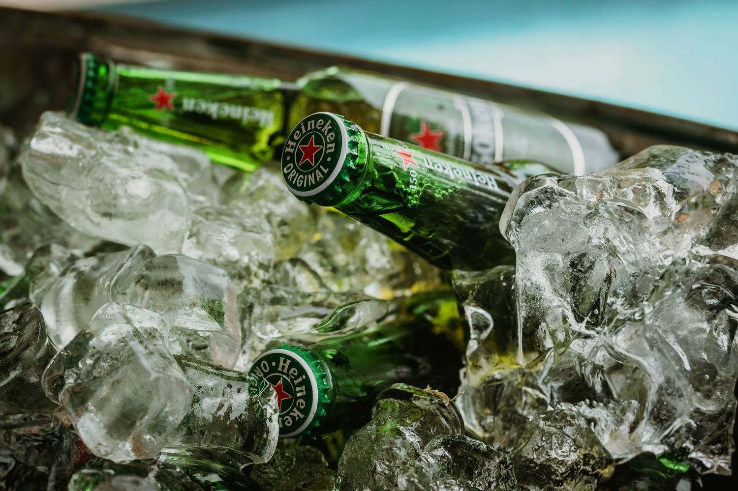 Heineken beer bottles chilling on ice in a cooler, perfect for parties and events.