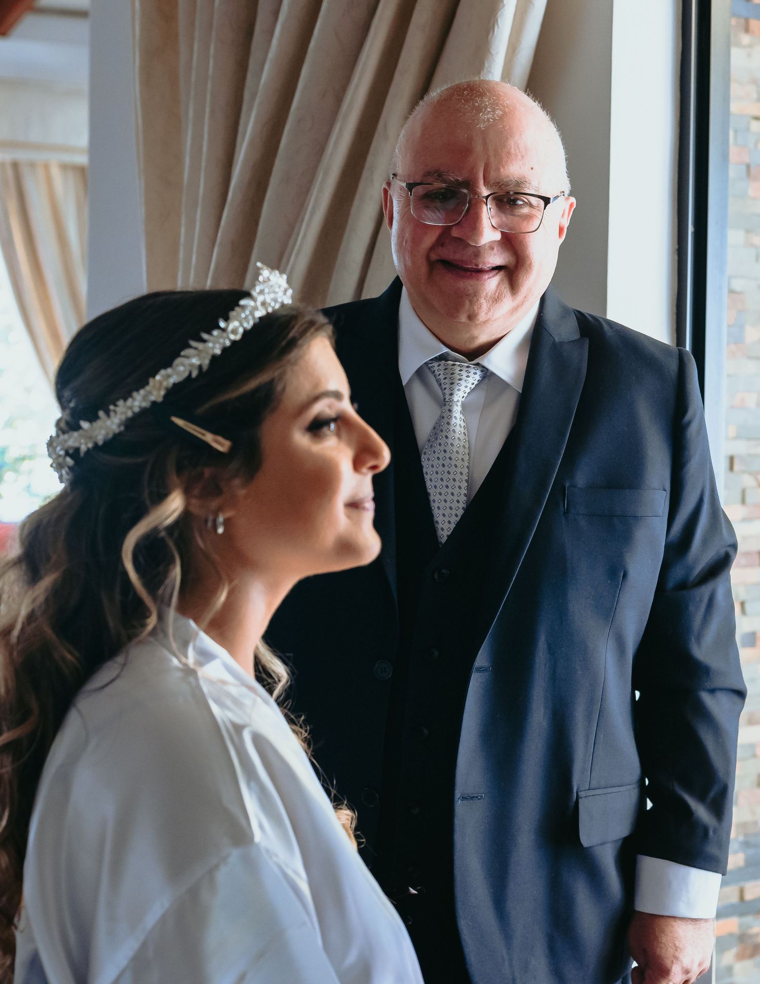 Proud father smiling at his beautiful bride daughter before wedding ceremony.
