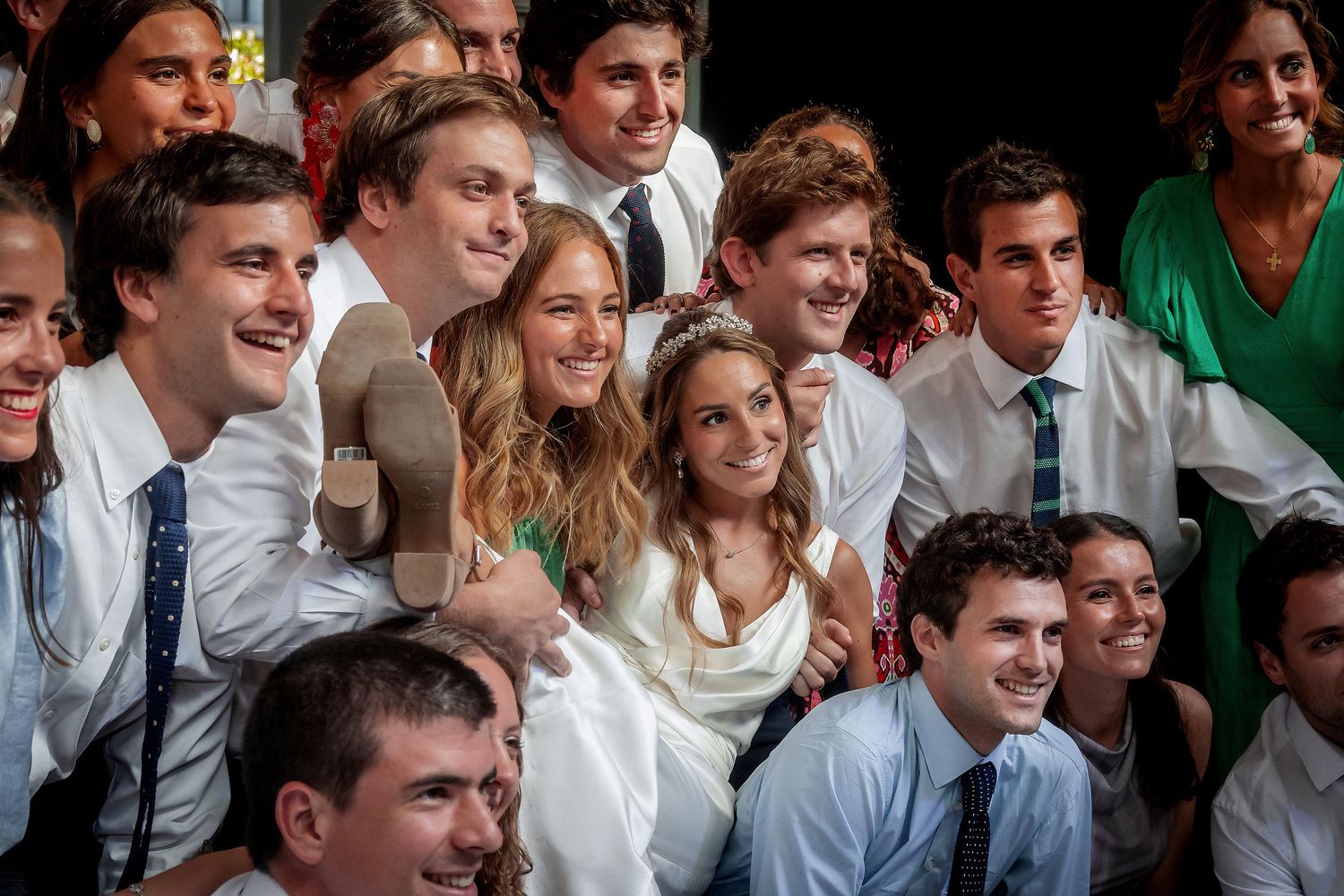Large group of young wedding guests posing together for a fun group photo.