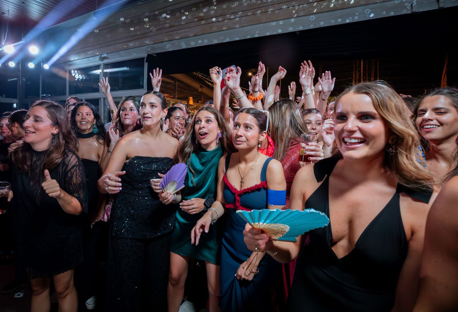 Excited women guests celebrate at elegant wedding reception party in formal attire.