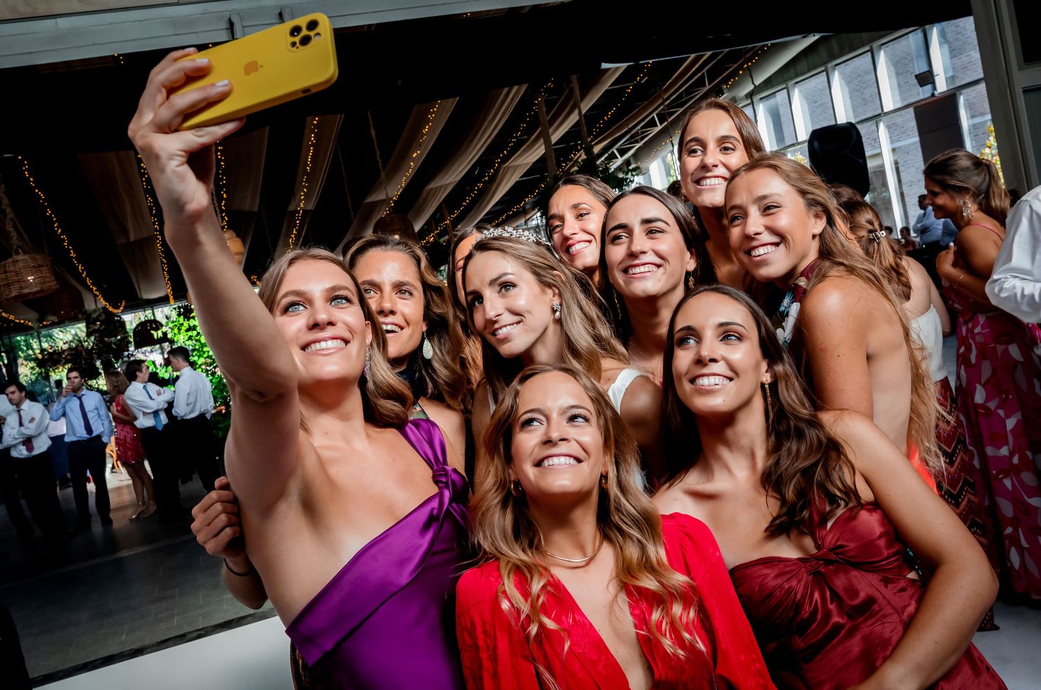 Bridesmaids and guests take a fun selfie together at a wedding reception.