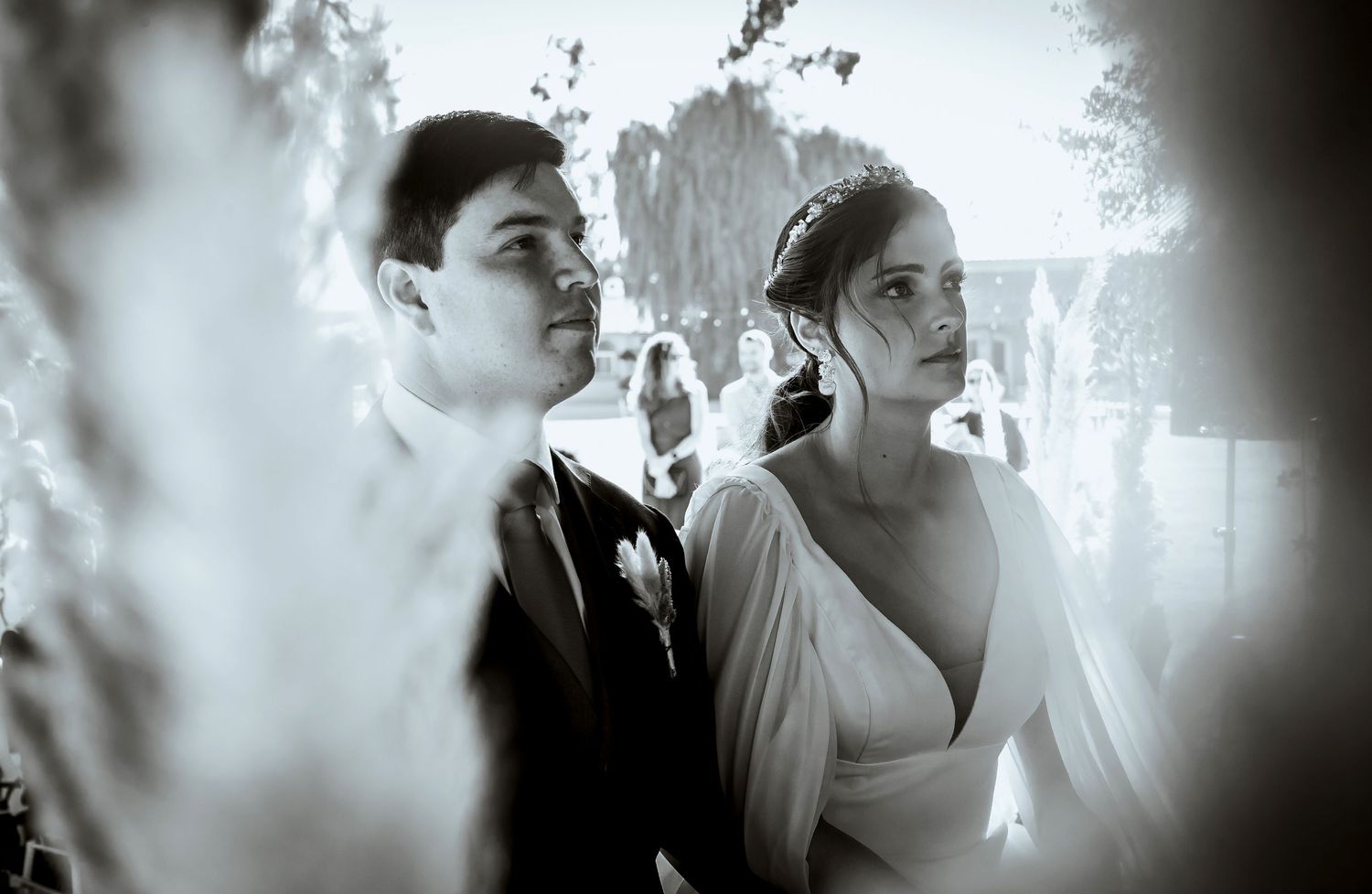 Black and white photo of bride and groom at outdoor wedding ceremony.