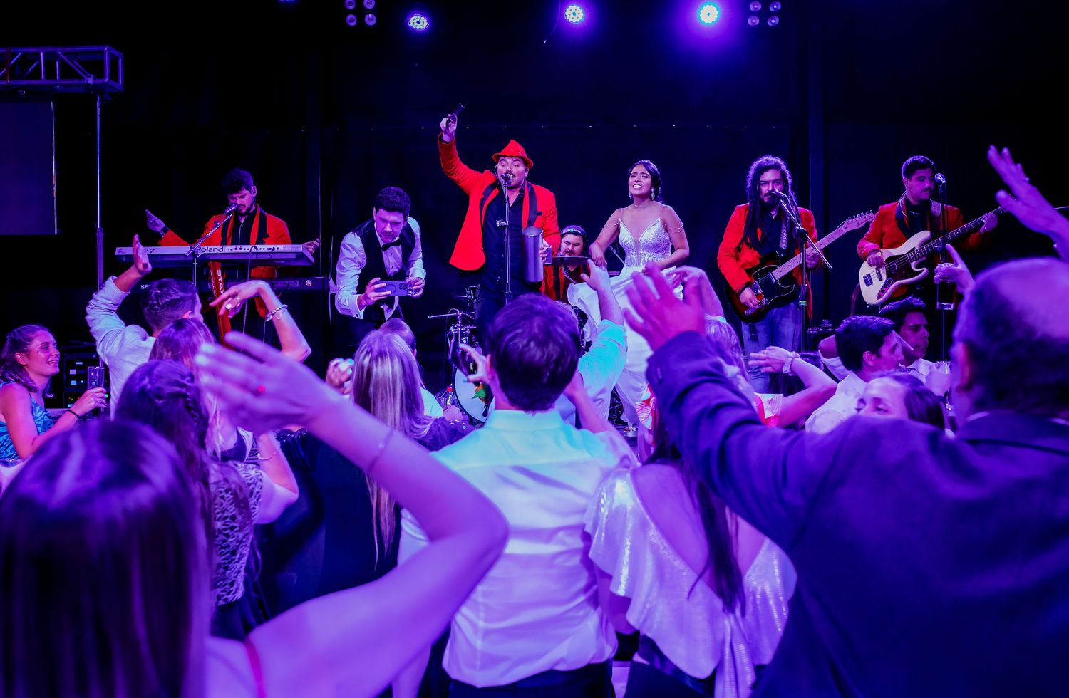 Live band performing on stage for dancing wedding guests at an energetic reception.