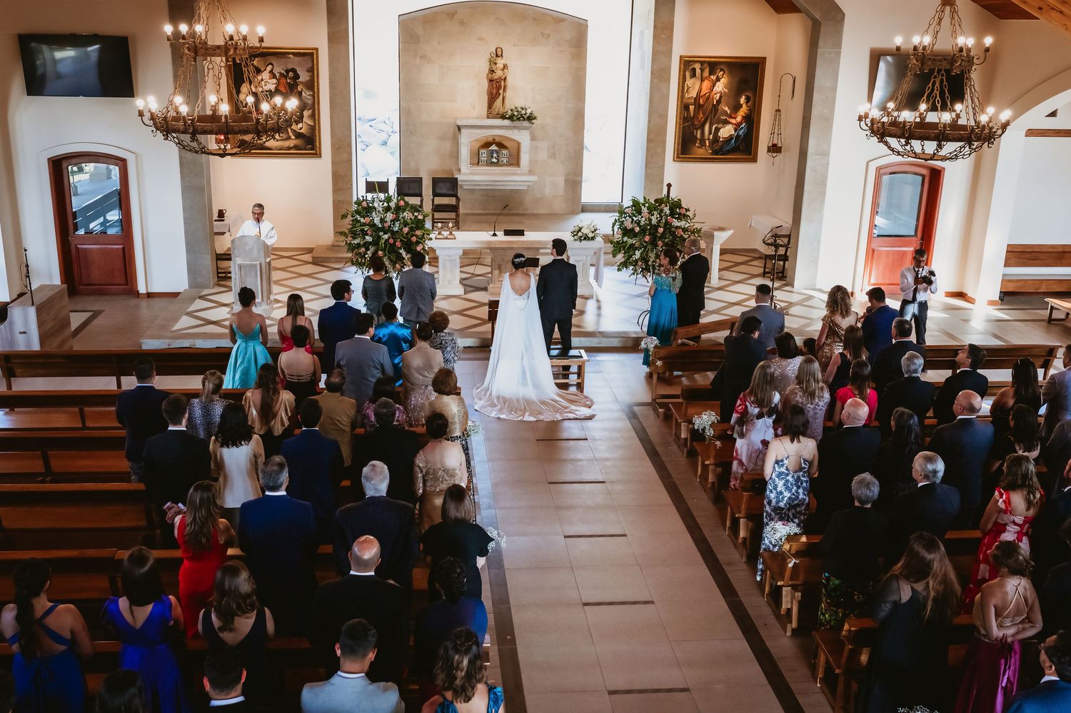 Aerial view of wedding ceremony in church with bride and groom standing at the altar.