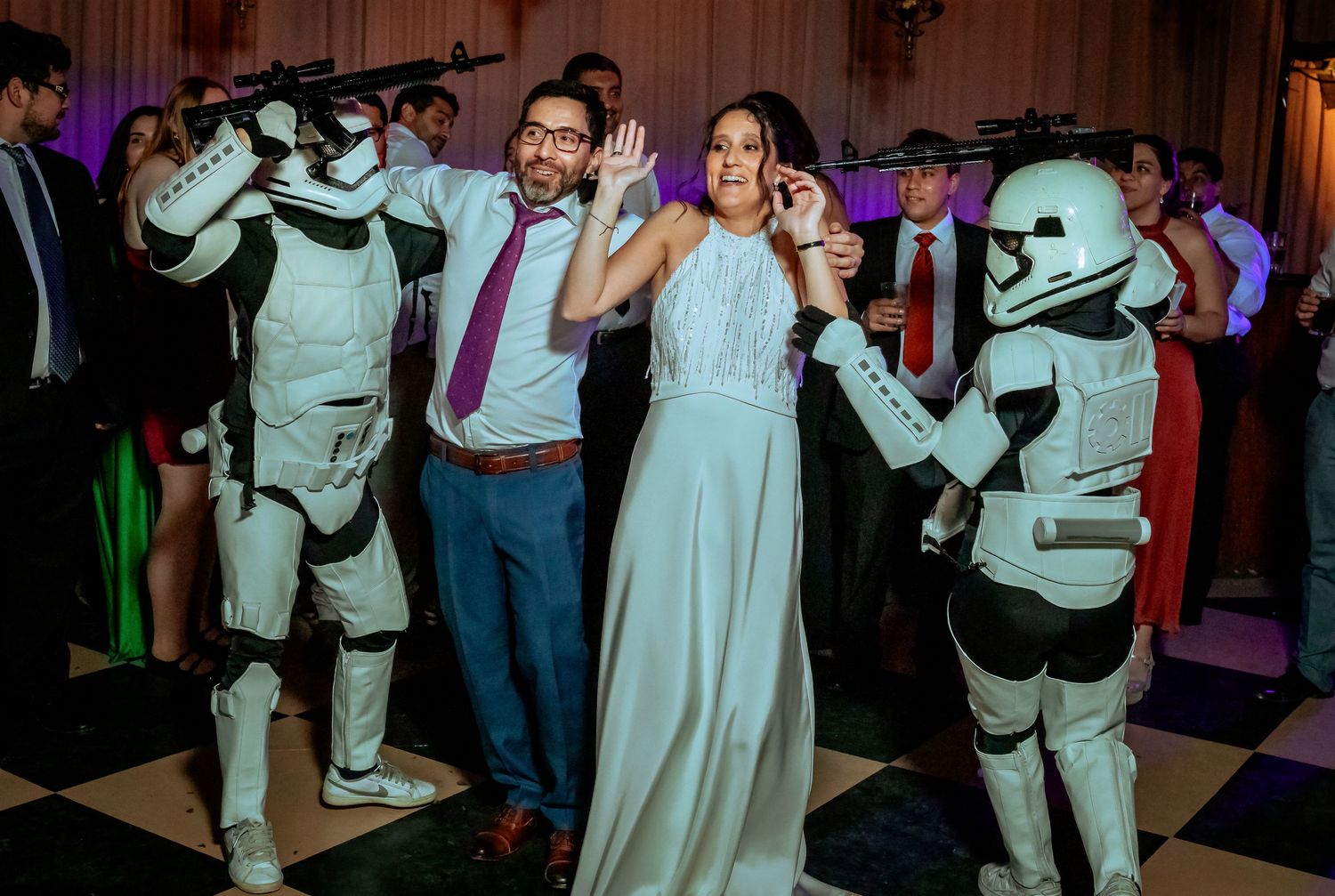 Couple posing with Star Wars Stormtroopers on a wedding reception dance floor.