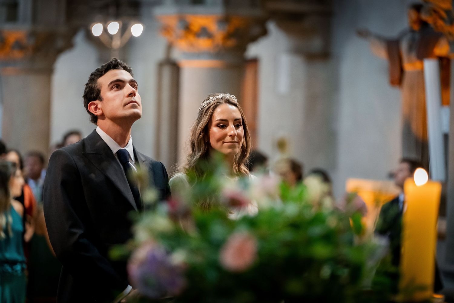 Bride and groom stand together at the altar during their elegant church wedding ceremony.
