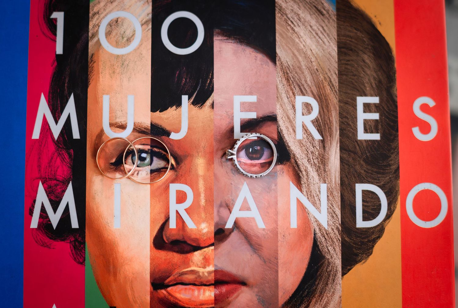 Colorful mural featuring diverse women\u2019s faces with the text 100 Mujeres Mirando displayed prominently.