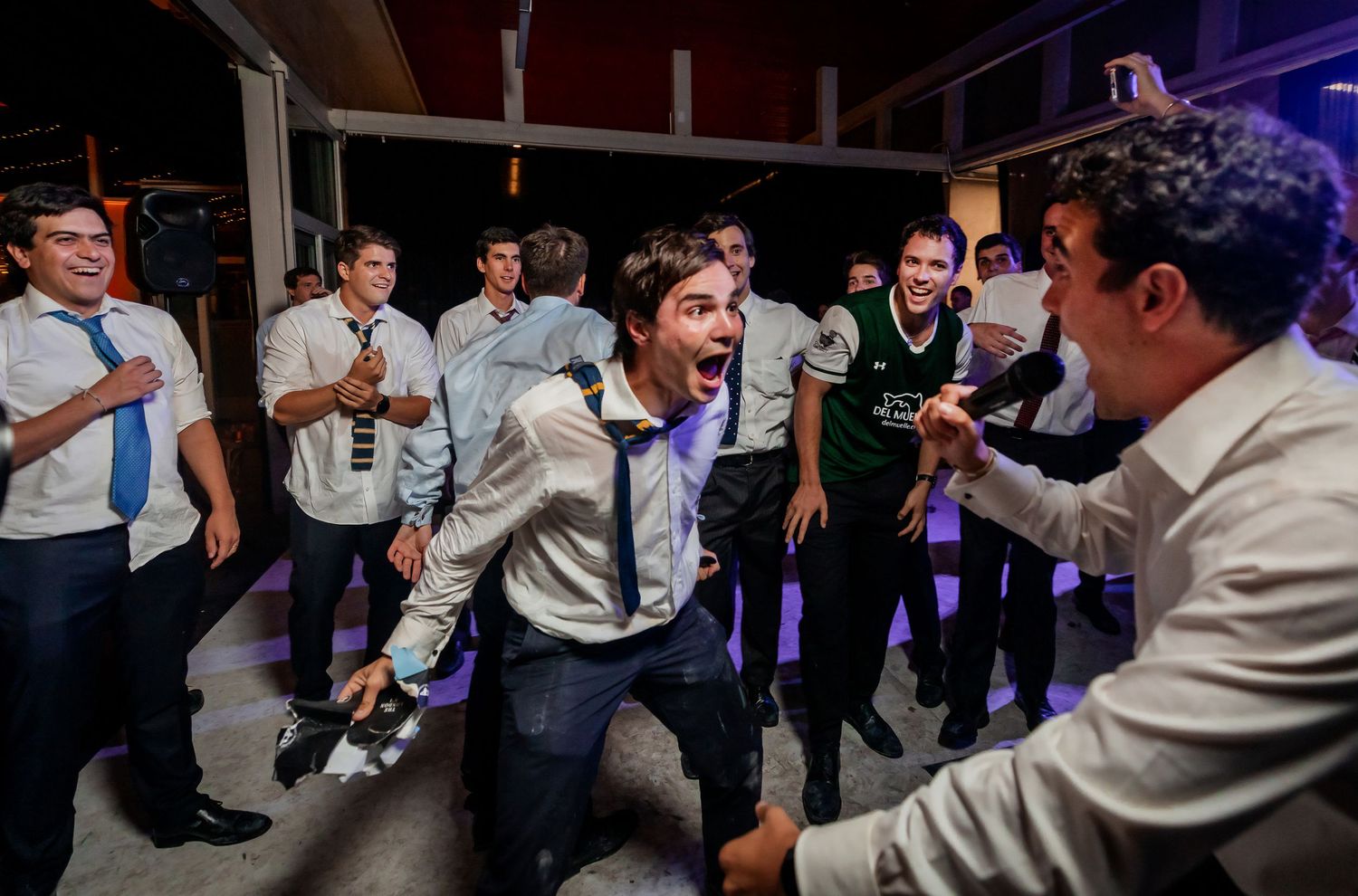 Enthusiastic wedding guest dancing and celebrating with friends at a lively reception party.