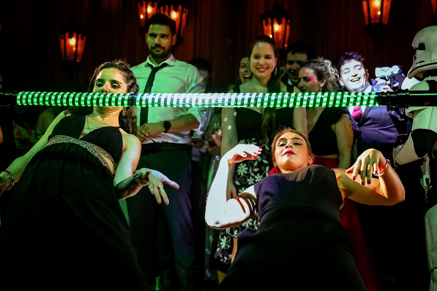 Guests dancing and celebrating at elegant wedding reception with green LED light bar.