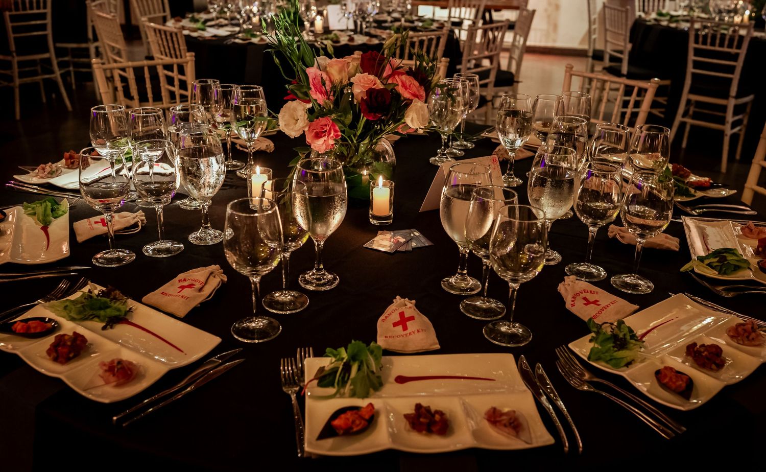Elegant wedding reception table set with crystal glasses, floral centerpiece, and candles.