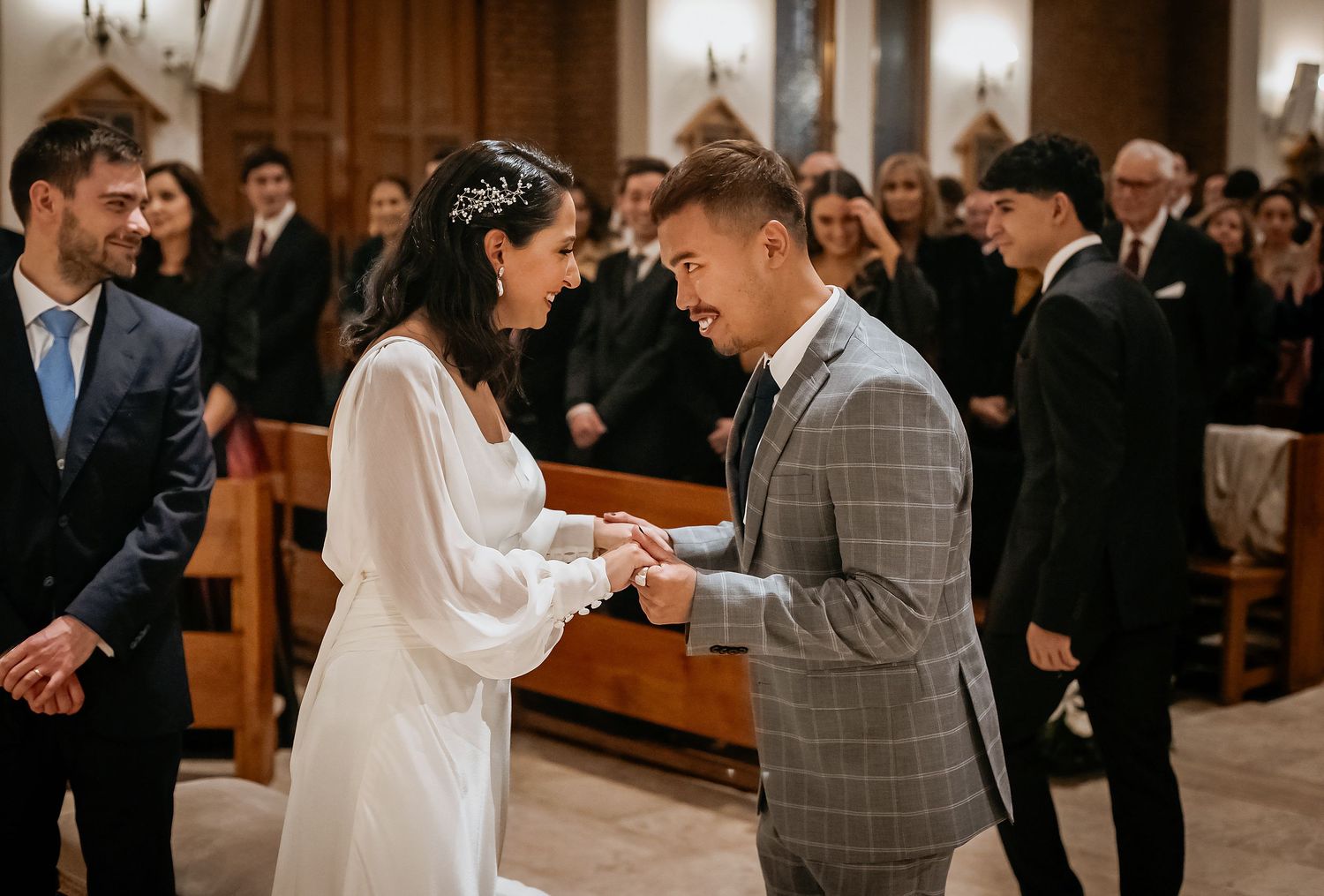 Bride and groom exchange rings at church altar during elegant wedding ceremony.