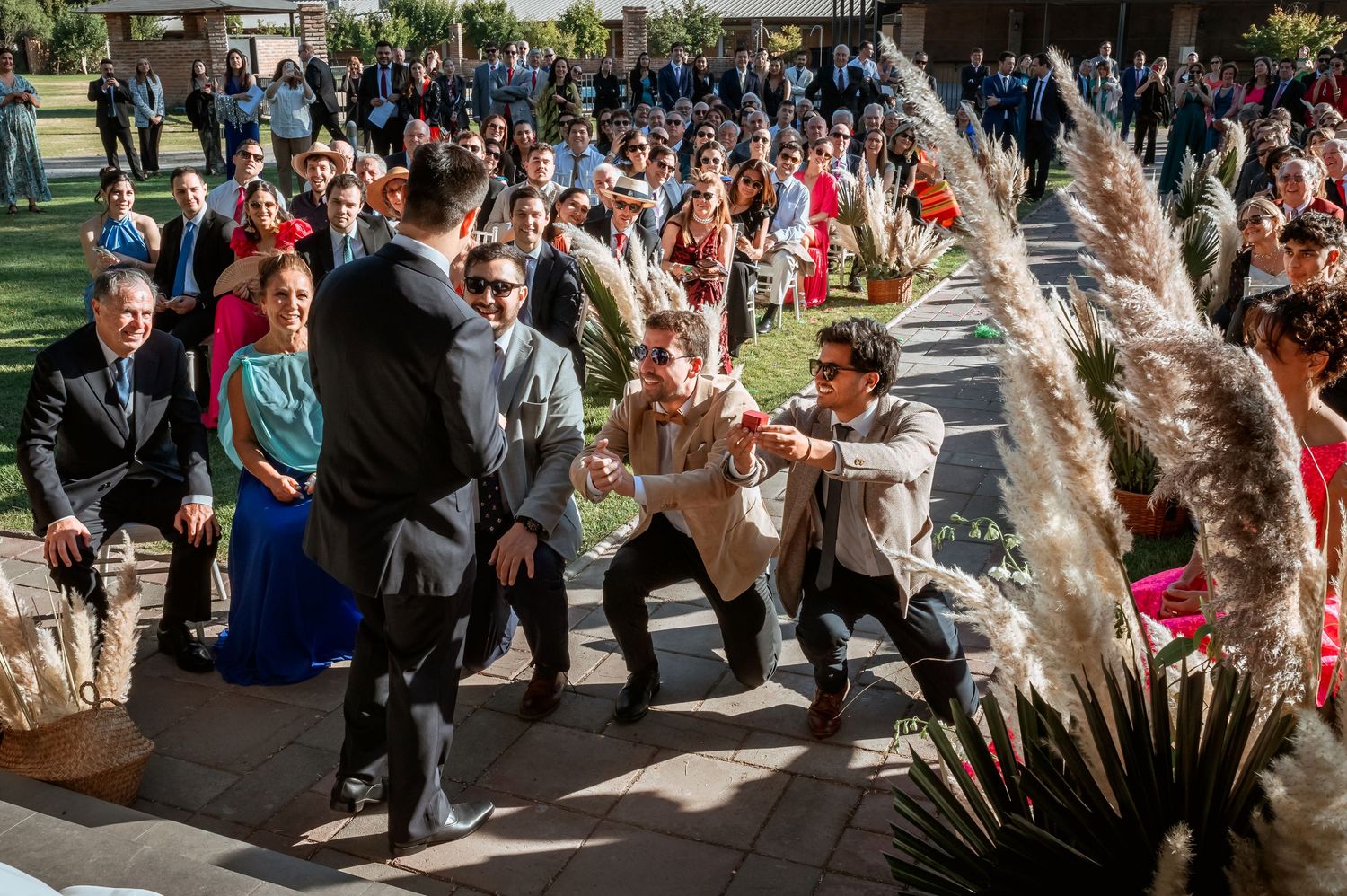 Wedding guests joyfully dancing and celebrating along the aisle during an outdoor wedding ceremony.
