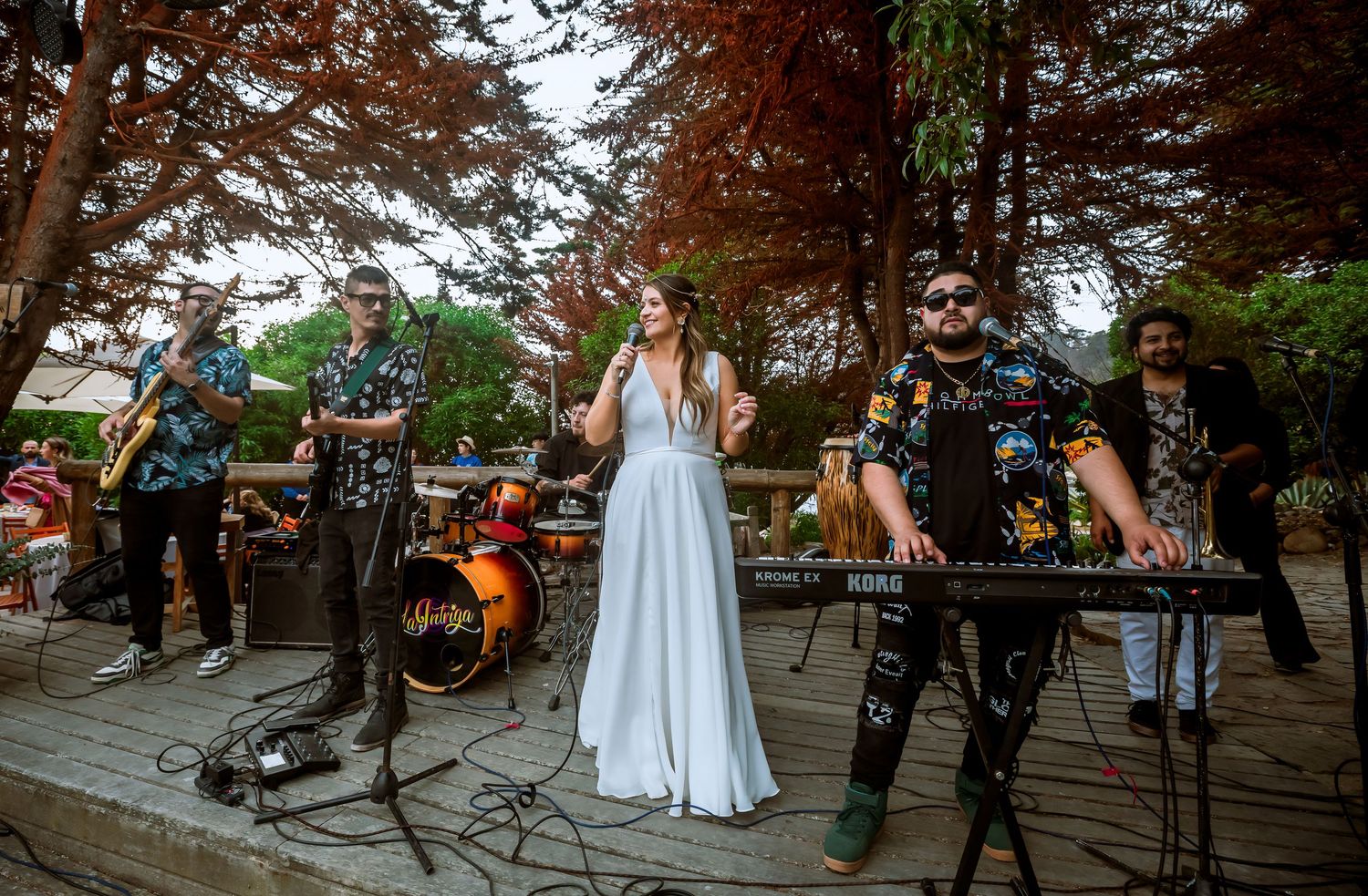 Live wedding band performing outdoors featuring a bride in white dress singing with musicians.