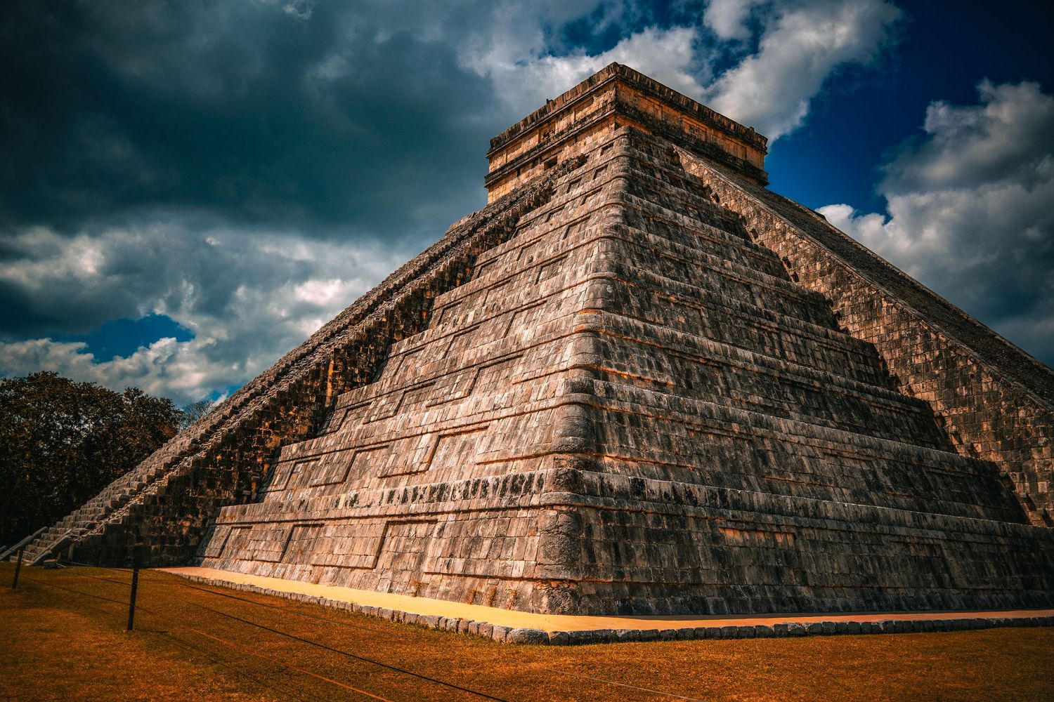 Ancient Mayan pyramid El Castillo at Chichen Itza, Mexico, under dramatic cloudy sky, a UNESCO World Heritage Site.