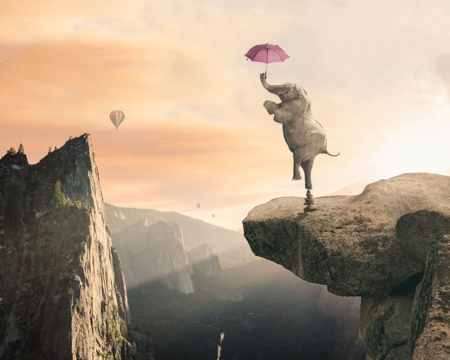 A surreal elephant balancing on a rocky cliff edge holding a pink umbrella with hot air balloons in a misty mountain backdrop.