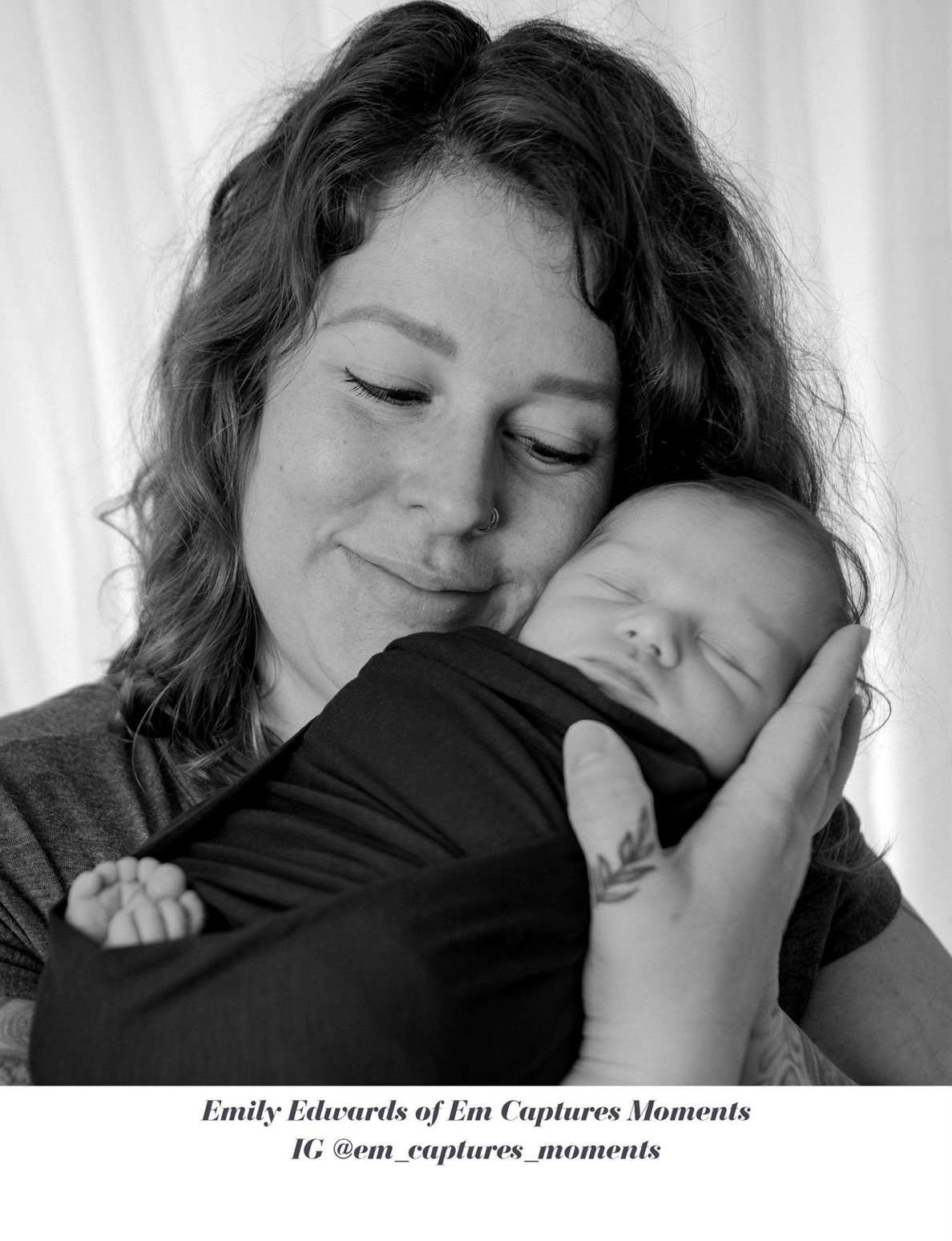 Black and white photo of a mother tenderly holding her sleeping newborn baby close to her cheek.